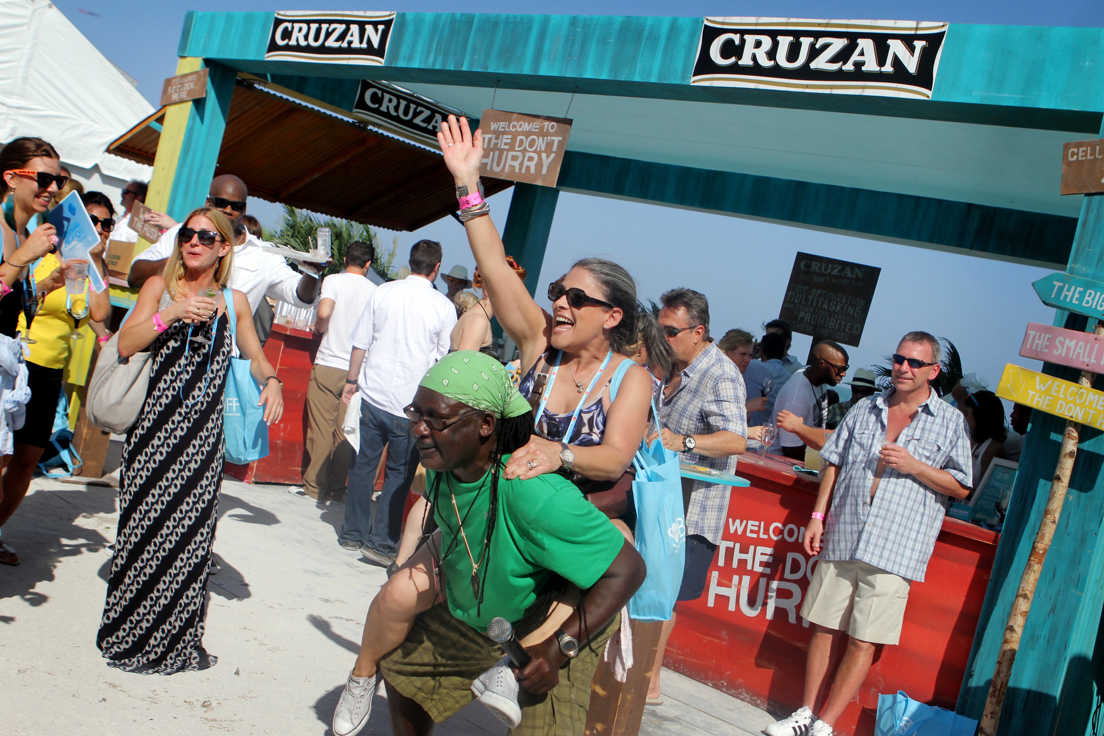Carmen Raia of Miami Shores gets a piggy-back ride from musician Albert Albee Amoroso at the Grand Tasting Village on Saturday afternoon. Scenes from South Beach Food and Wine Festival in Miami Beach. (J. Gwendolynne Berry/The Palm Beach Post)