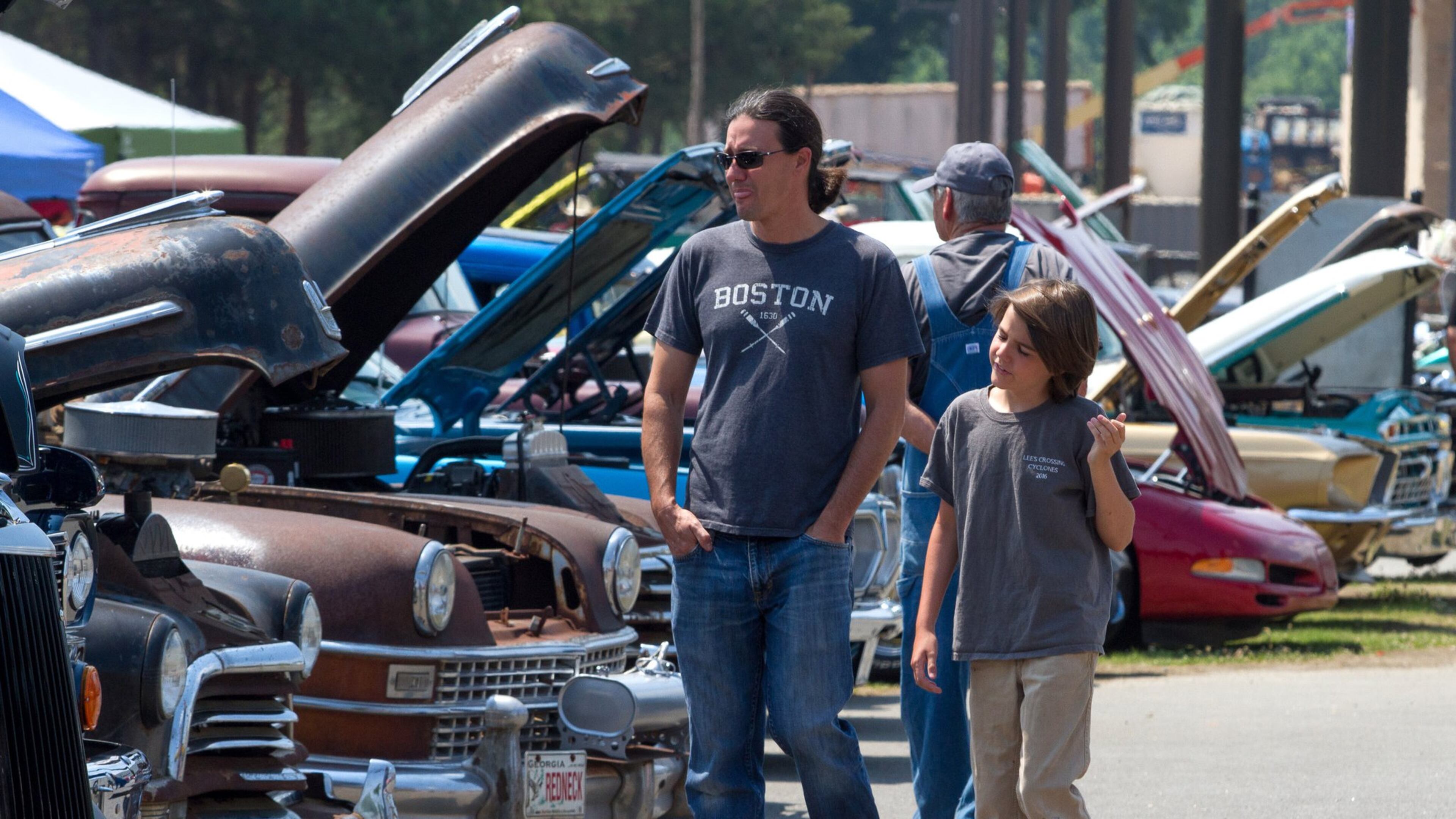 Marc Vanwinkle looks over the old restored cars with his son Rigby during last year’s Creeper’s Car Show at Jim Miller Park in Marietta. STEVE SCHAEFER / SPECIAL TO THE AJC
