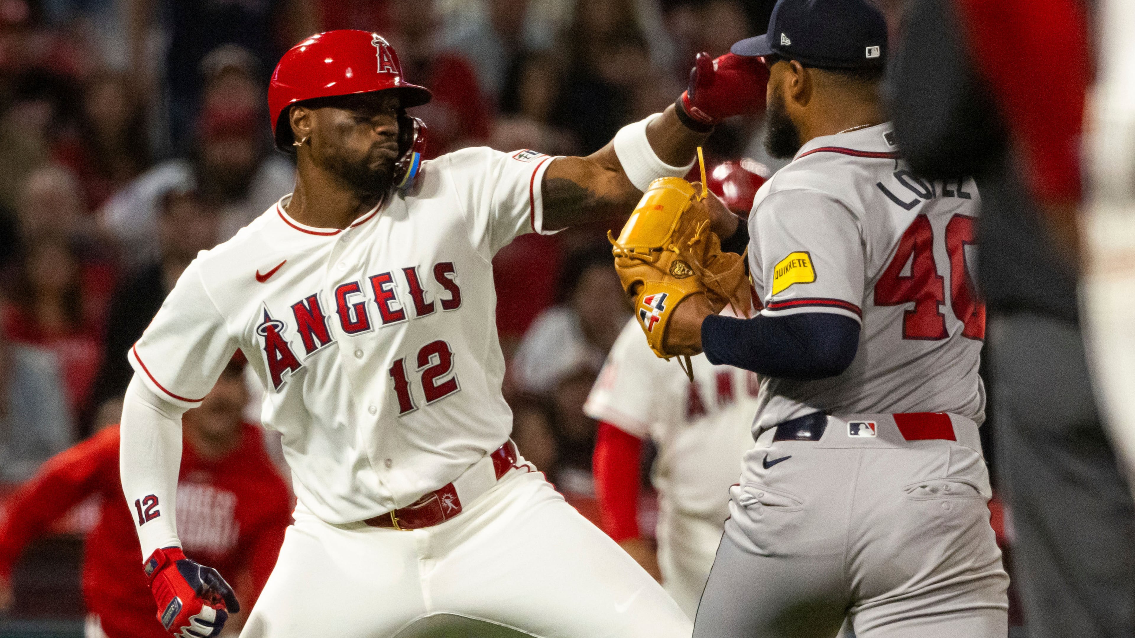 Los Angeles Angels' Jorge Soler (12) and Atlanta Braves' Reynaldo López (40) fight during the fifth inning of a baseball game, Tuesday, April 7, 2026, in Anaheim, Calif. (AP Photo/Ethan Swope)