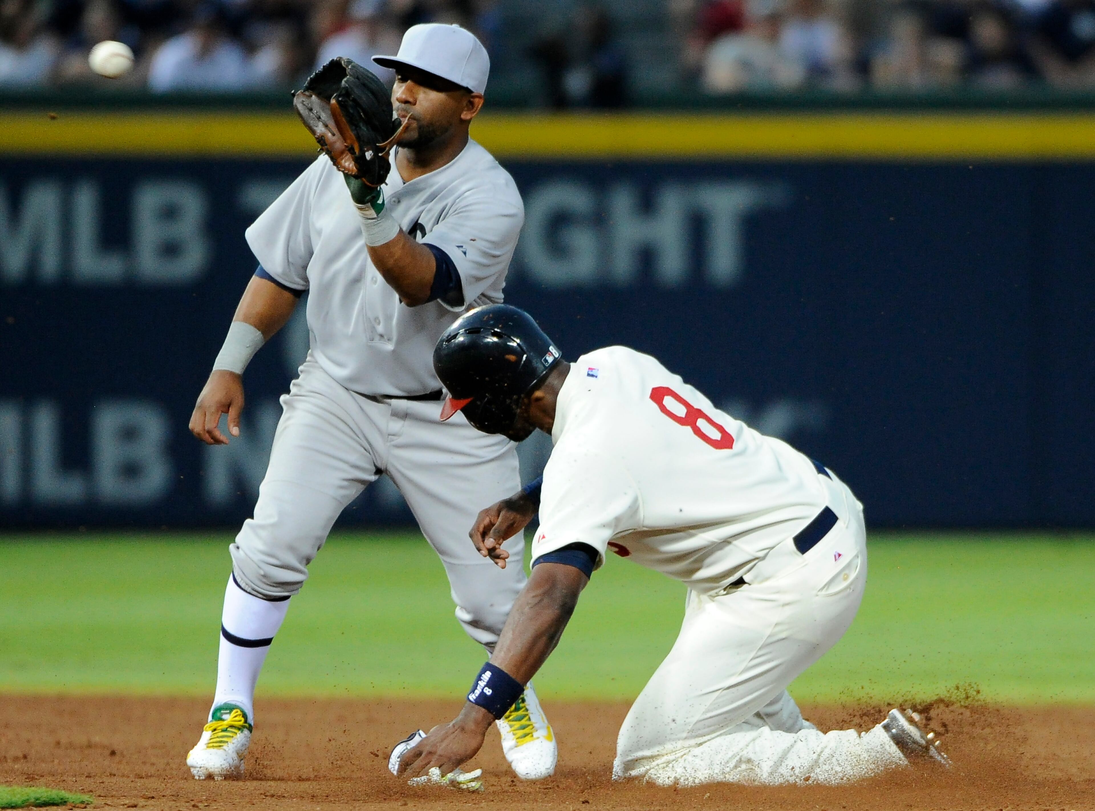 Atlanta Braves' Justin Upton (8) is safe at second base as Oakland Athletics' Alberto Callaspo fields the late throw on a wild pitch during the fourth inning of a baseball game Saturday, Aug. 16, 2014, in Atlanta. (AP Photo/David Tulis)