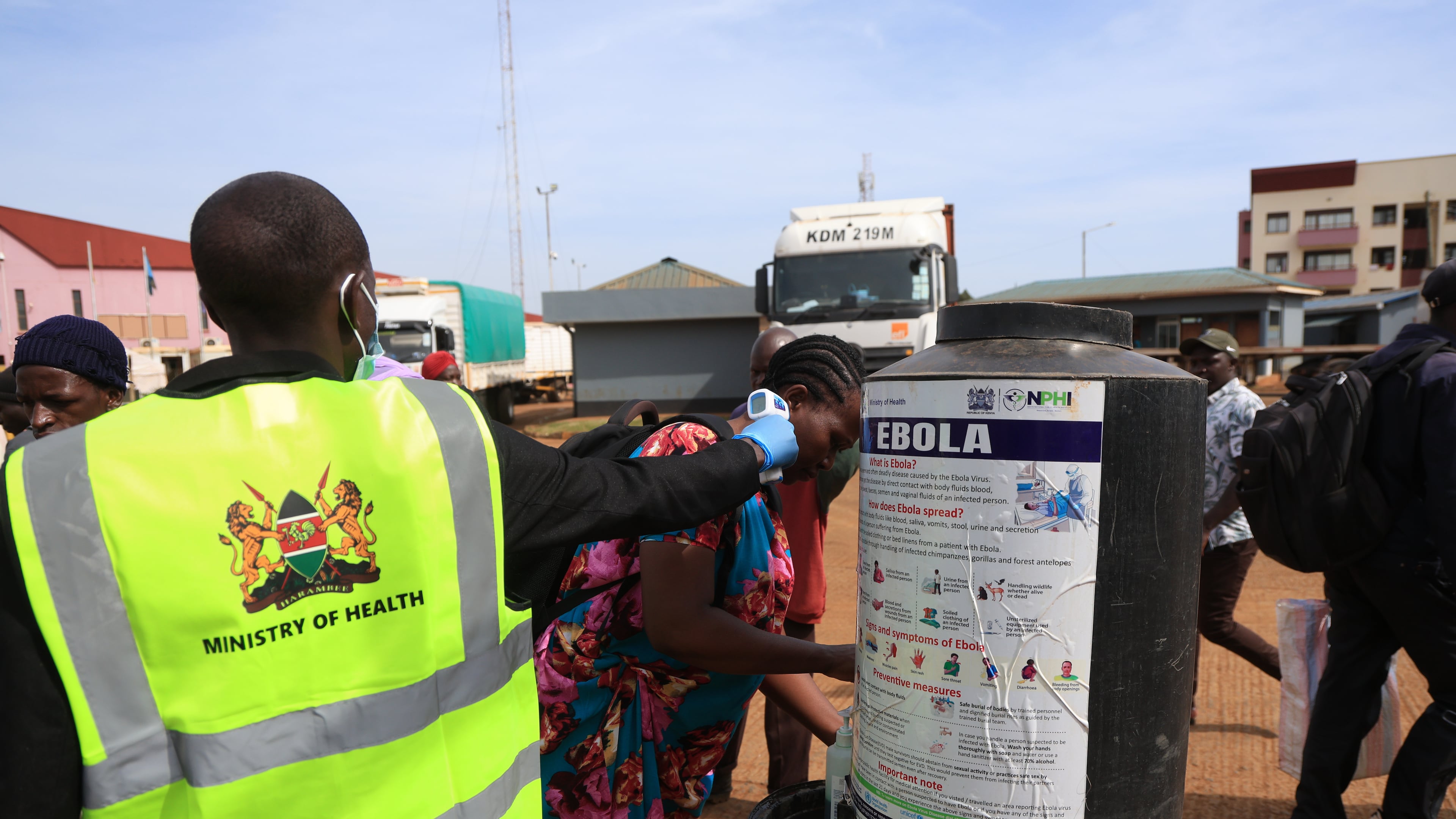 People disinfect their hands as a Kenyan health worker checks the temperatures of travelers crossing from Uganda to Kenya as part of measures to contain the spread of Ebola virus, in Busia, Kenya, Thursday, Oct. 15, 2026. (AP Photo/Andrew Kasuku)