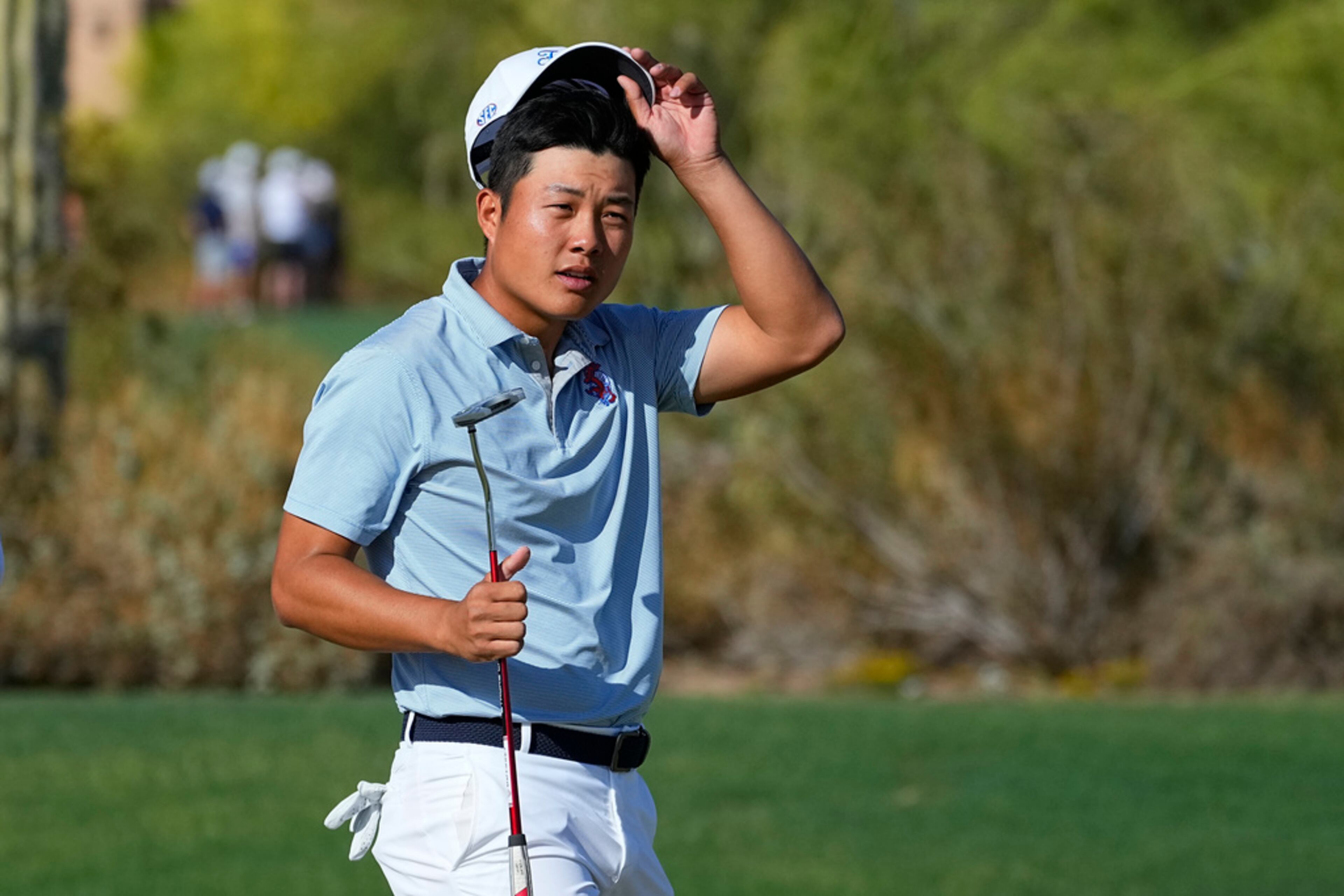 Florida golfer Yuxin Lin tips his cap after winning his match against Georgia Tech golfer Christo Lamprecht during the final round of the NCAA college men's match play golf championship, Wednesday, May 31, 2023, in Scottsdale, Ariz. (AP Photo/Matt York)