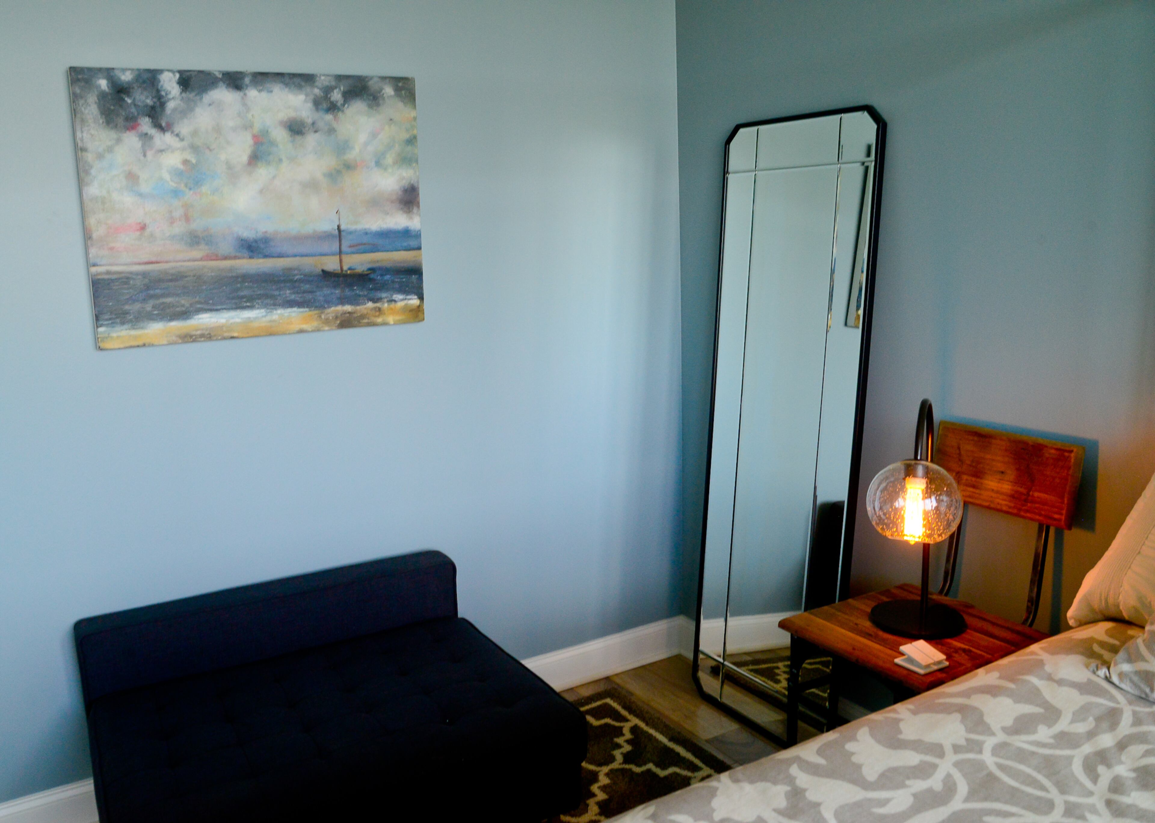 A painting called, "Boat in Stormy Waters," which was her son's college project, fits with the walls painted Breezy in the guest room. Throughout the condo, Bertolli Floors installed walnut floors from Armstrong to lighten up the flooring, which previously was an espresso hue.