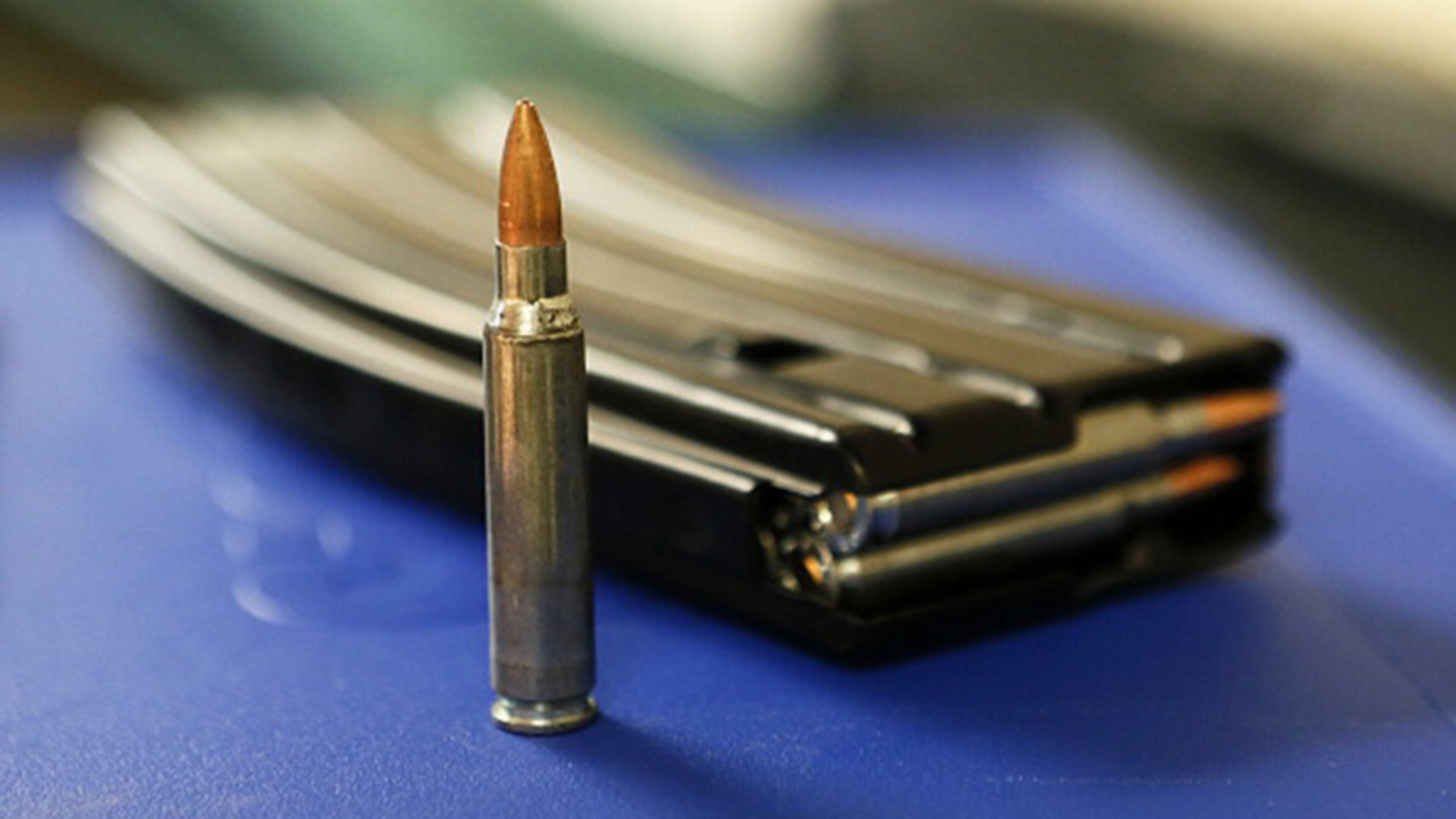 A bullet and high capacity 30-round clip sit on a table at "Get Some Guns & Ammo" shooting range