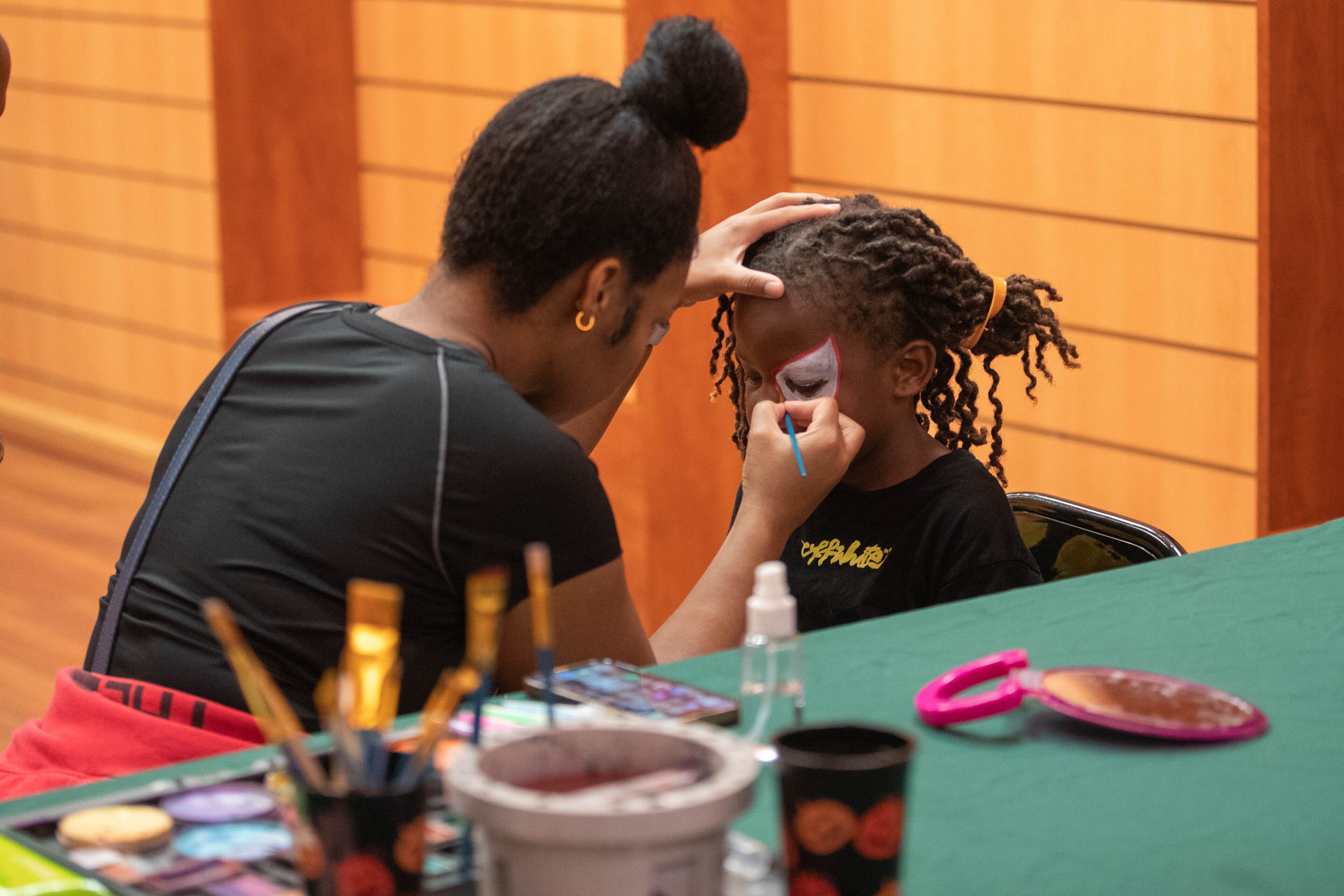 Amir B, 8, receives free face painting by Alex Muse at the 20th annual Back-to-School Bash at Greenbriar Mall in Atlanta on Saturday, July 22, 2023. (Katelyn Myrick/katelyn.myrick@ajc.com)