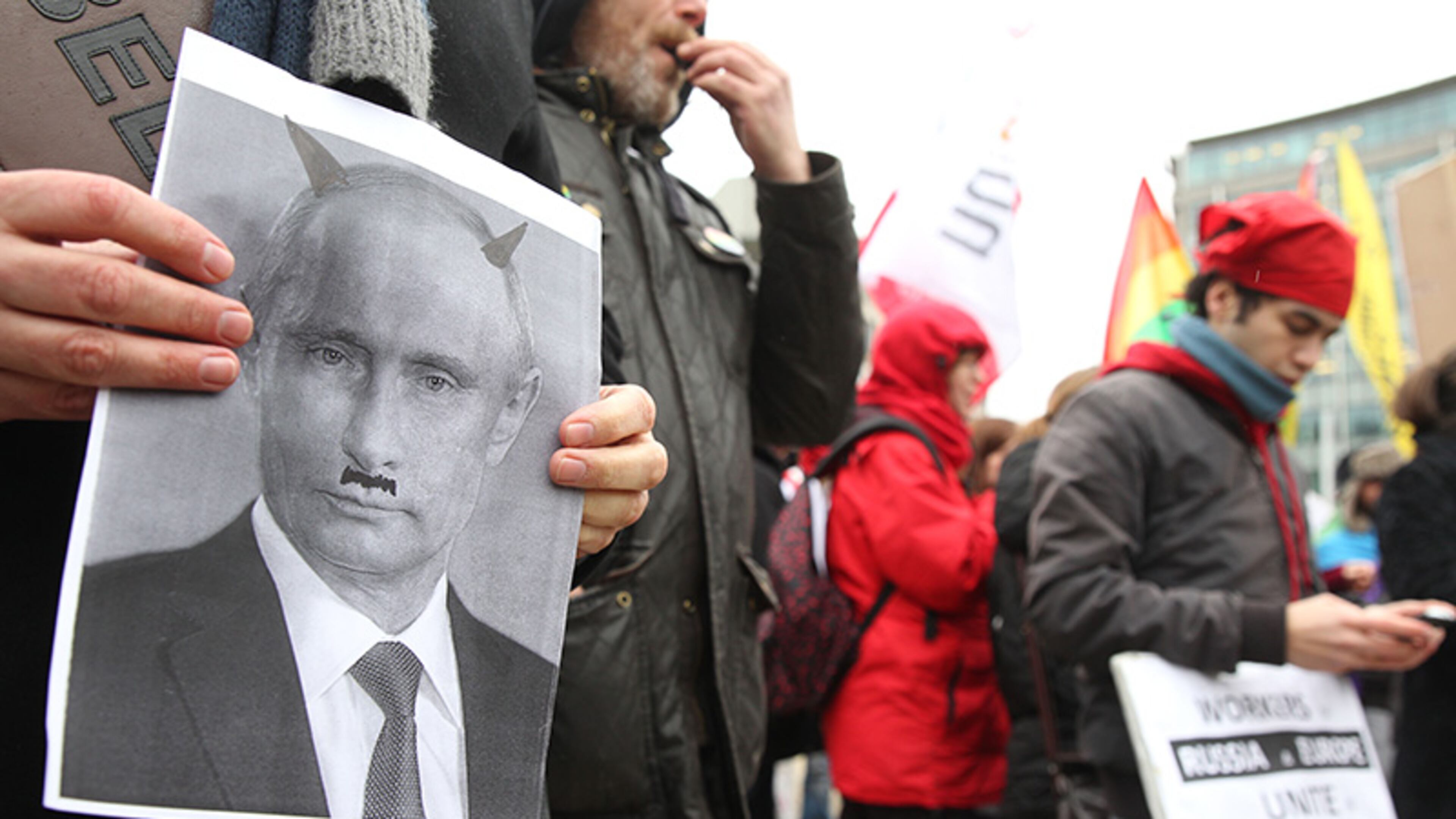 A gay-rights activist shows a photo of Russia's President Vladimir Putin depicted as a devil, as protesters gather at a square next to the European institutions, in Brussels, Monday, Jan. 27, 2014. Despite months of protests, Russia's law against 'gay propaganda' remains in place, and no major boycott of the Russian-hosted Winter Olympics seems likely.