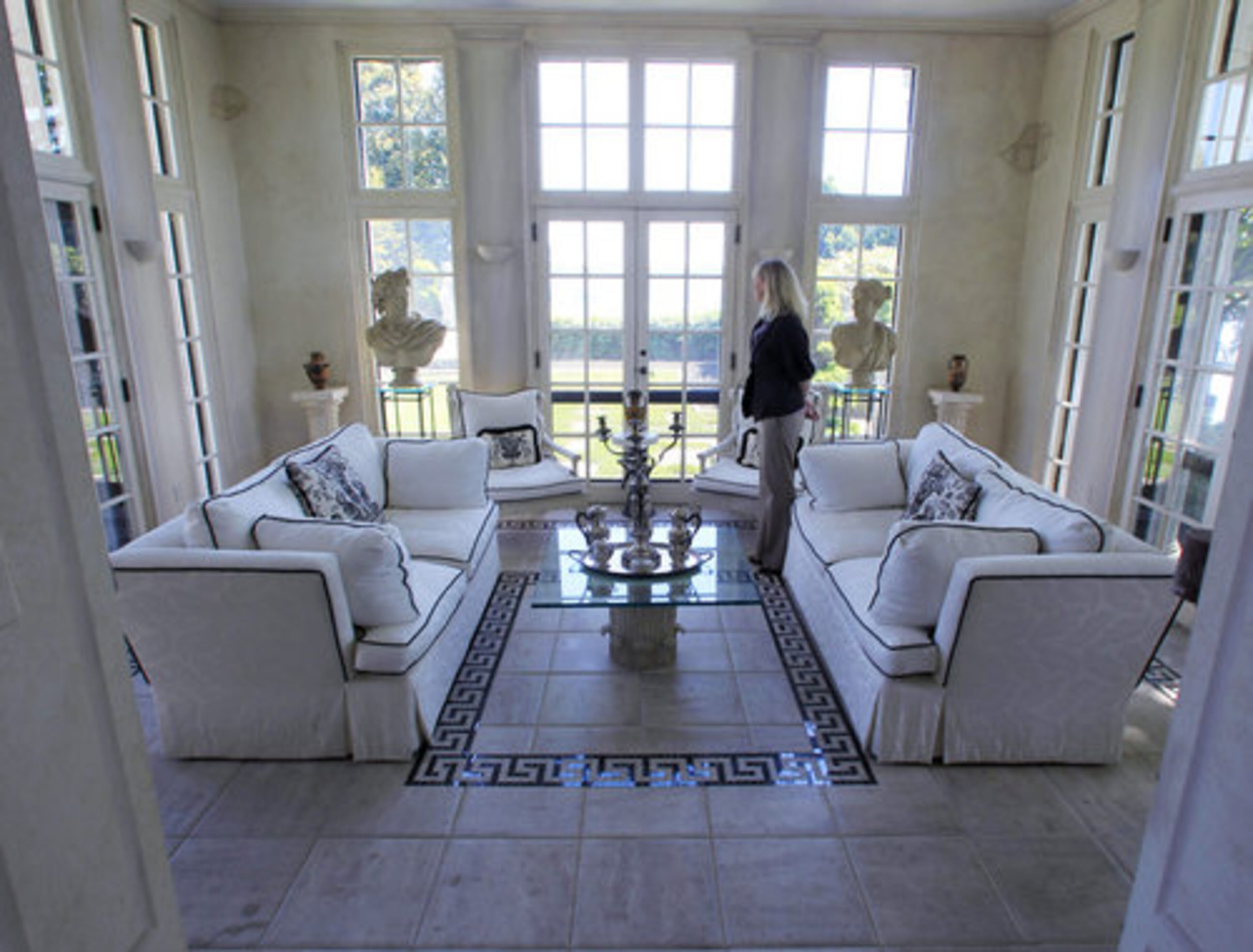 Roni Boyles of Coldwell Banker Real Estate stands in the sunroom at The Oaks estate in Cohasset, Mass.