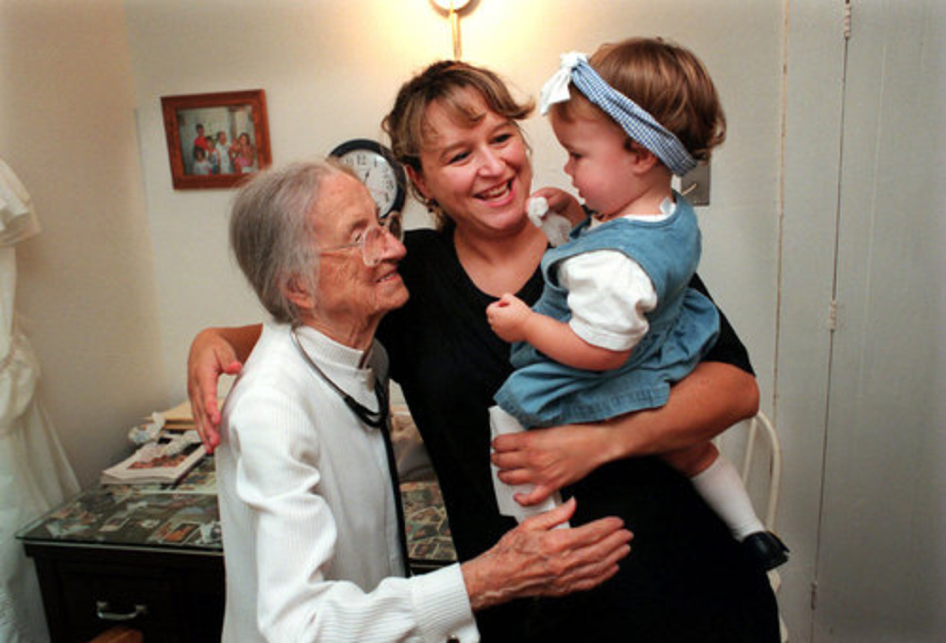 Scarlett Jimison, center, and her 14-month-old daughter Amber, hug then-100-year-old Dr. Leila Denmark goodbye after an office visit at her 125-year-old farmhouse in 1998. Jimison, who is from Buckhead, had been coming to Denmark since she was an infant and continued to bring her daughter.