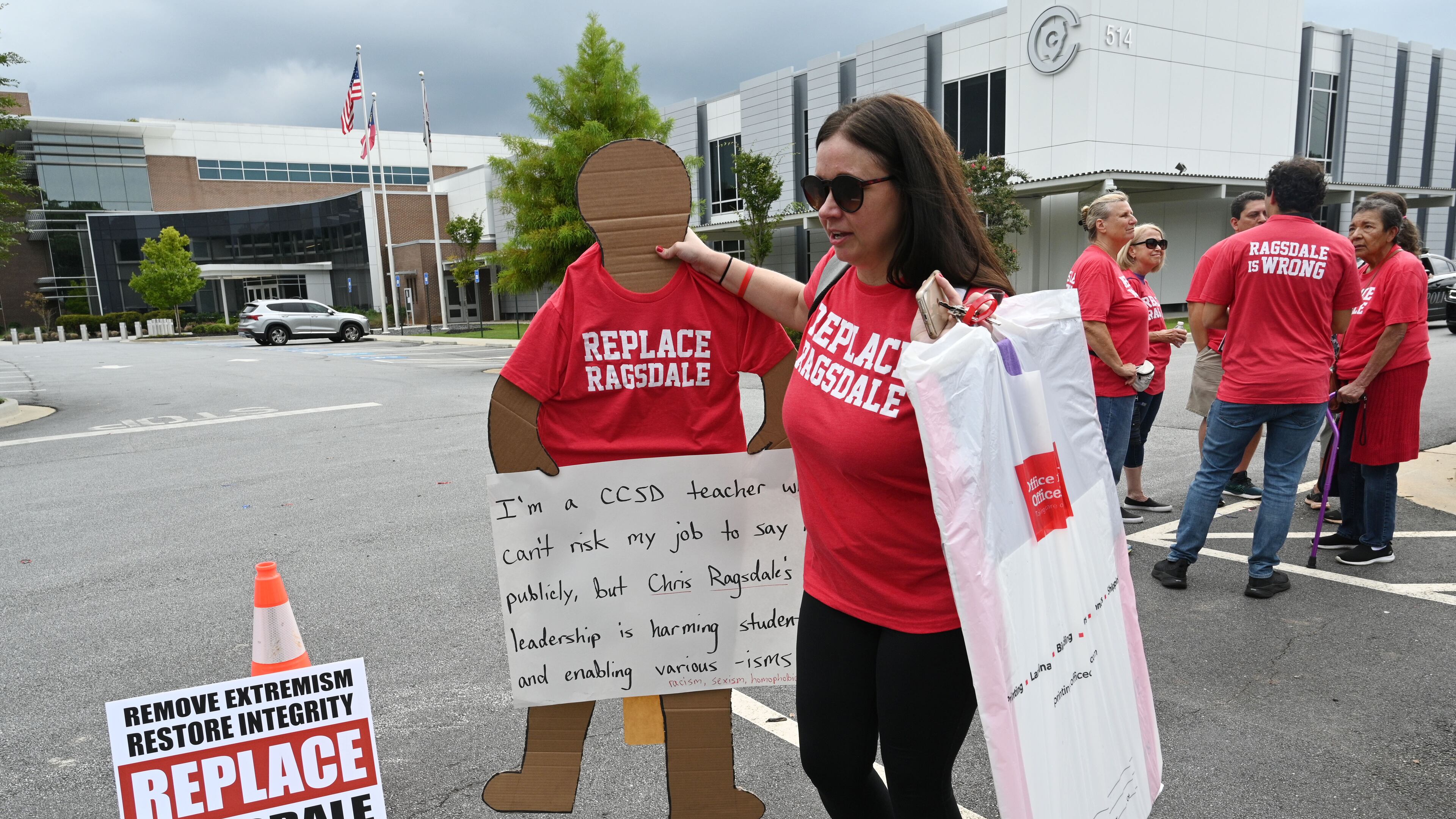 Jennifer Susko, one of the organizers of the "Replace Ragsdale" rally, holds a life-sized sign that a Cobb County teacher made and sent because the teacher was too afraid to attend the rally at the Cobb County School District building, Thursday, Sept. 14, 2023, in Marietta, in person. The school district's response to such actions has drawn criticism. (Hyosub Shin / Hyosub.Shin@ajc.com)