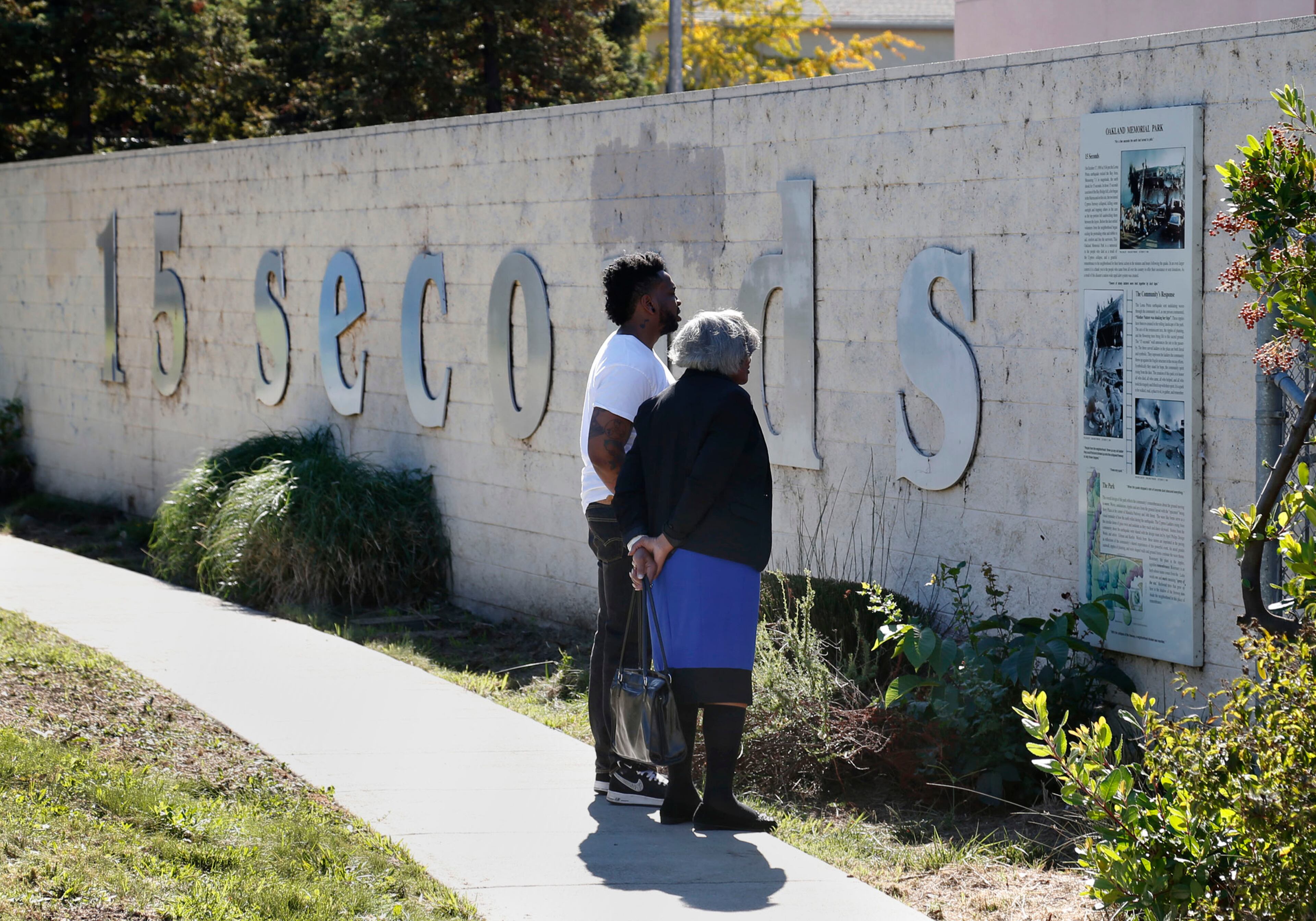 Chaz Mabry walks with his grandmother, Helene Hunter, at the Cypress Structure Freeway Memorial on October 12, 2014. He lost his mother nearby 25 years when she was killed in the Loma Prieta earthquake. The 15 second-long temblor claimed 42 lives. (Karl Mondon/Bay Area News Group/MCT)
