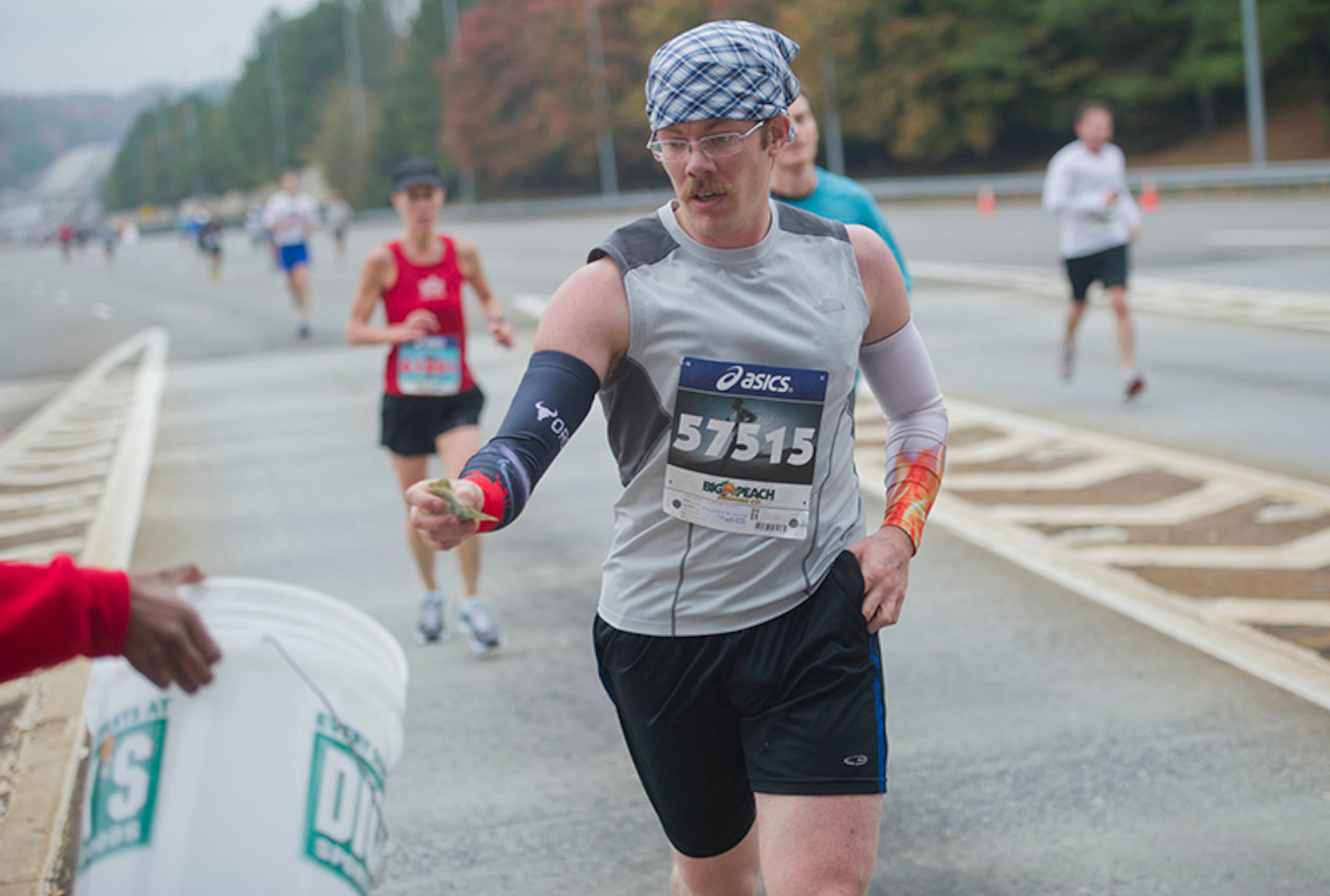 Rivers Ludden reaches out to drop money into a collection bucket at the toll booth on Ga. 400. Tolls collected during the race will benefit Children's Health Care of Atlanta.