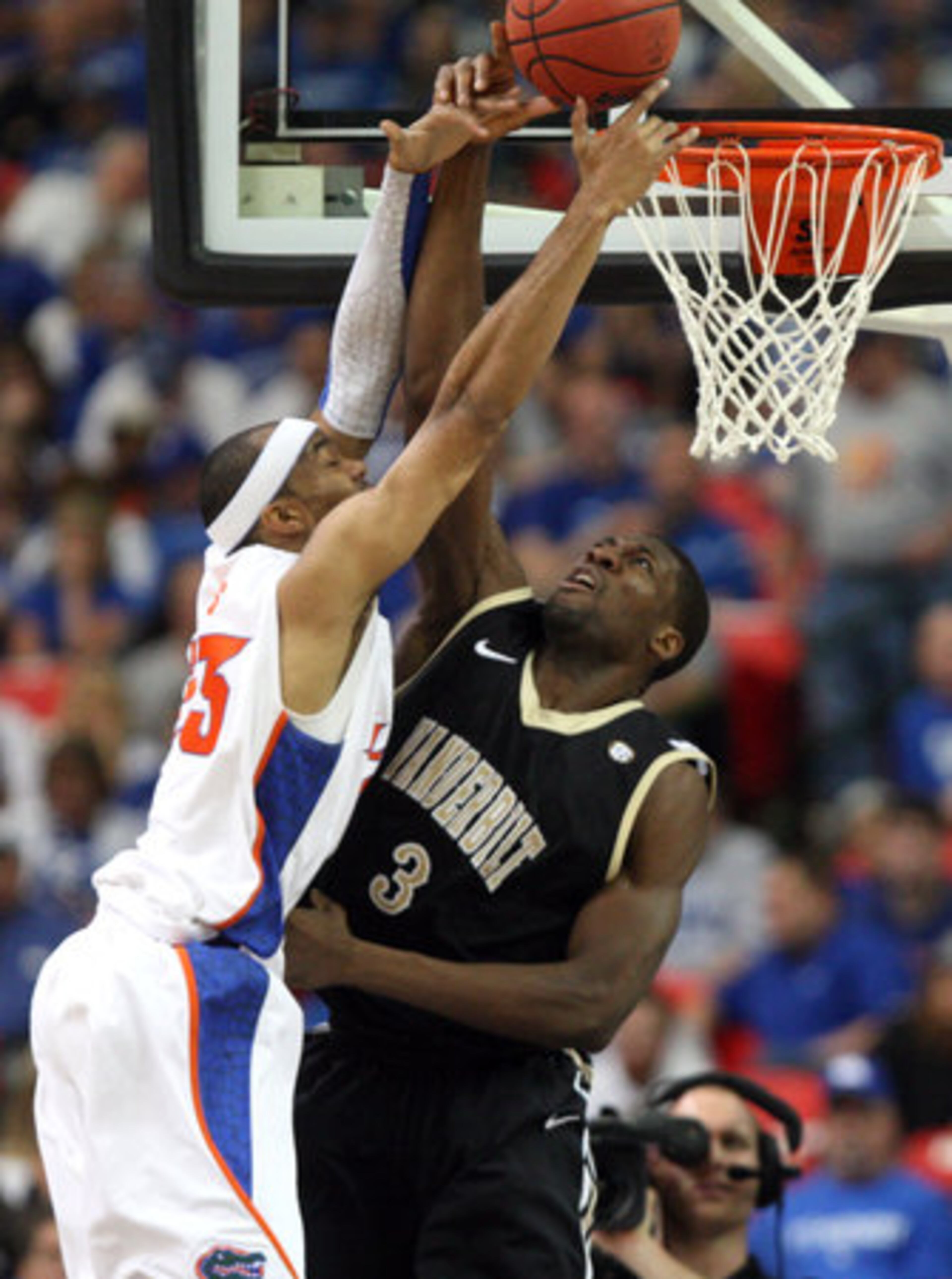 Florida's Alex Tyus, left, gets fouled by Vanderbilt's Festus Ezeli (3) as Tyus attempts a shot in the first half of an SEC tournament semifinal at the Georgia Dome on Saturday.