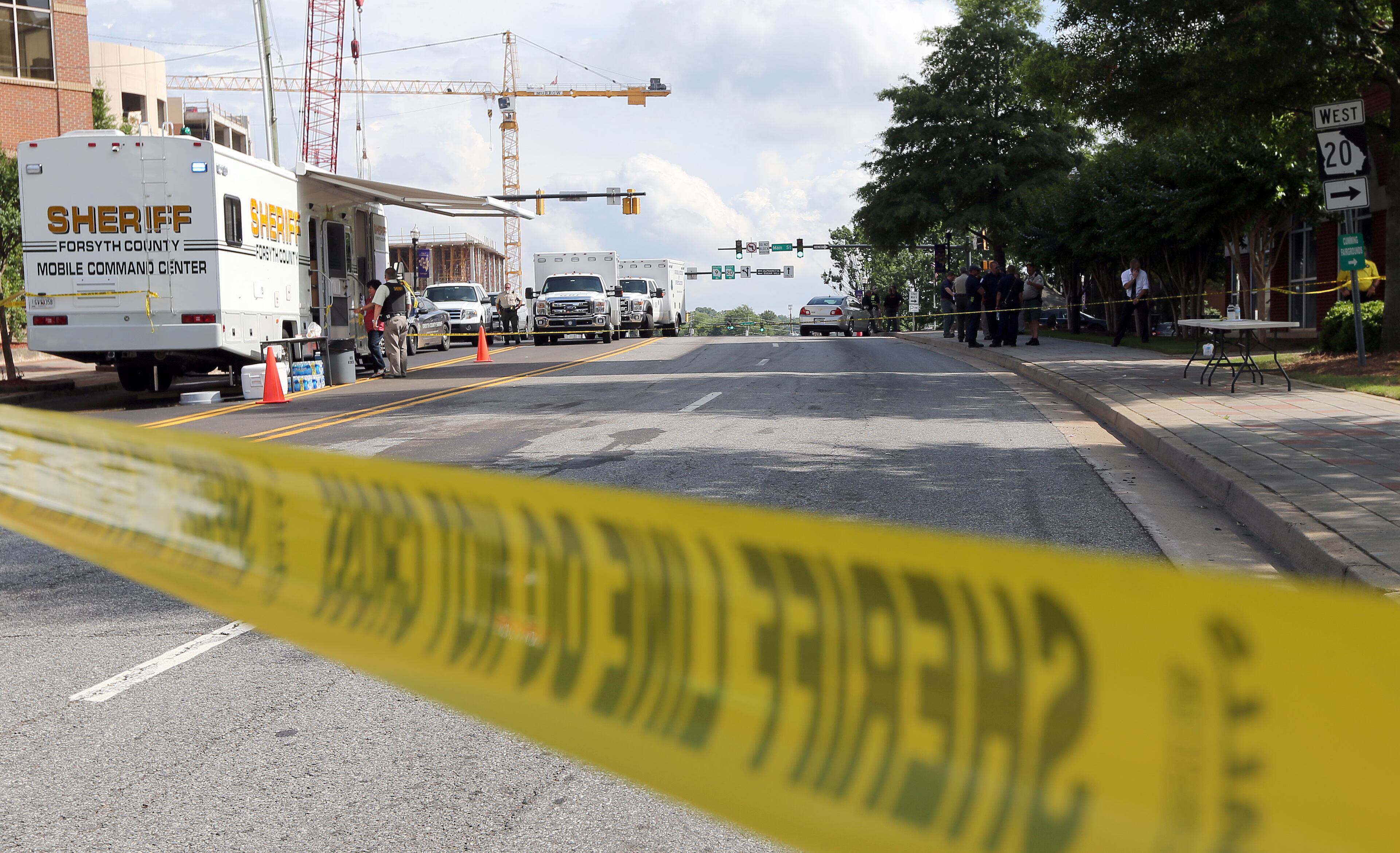 Crime scene tape blocks the roads near the Forsyth County Courthouse in Cumming on Friday afternoon June 6, 2014 following a morning shoot out that left one deputy injured and the perpetrator dead.