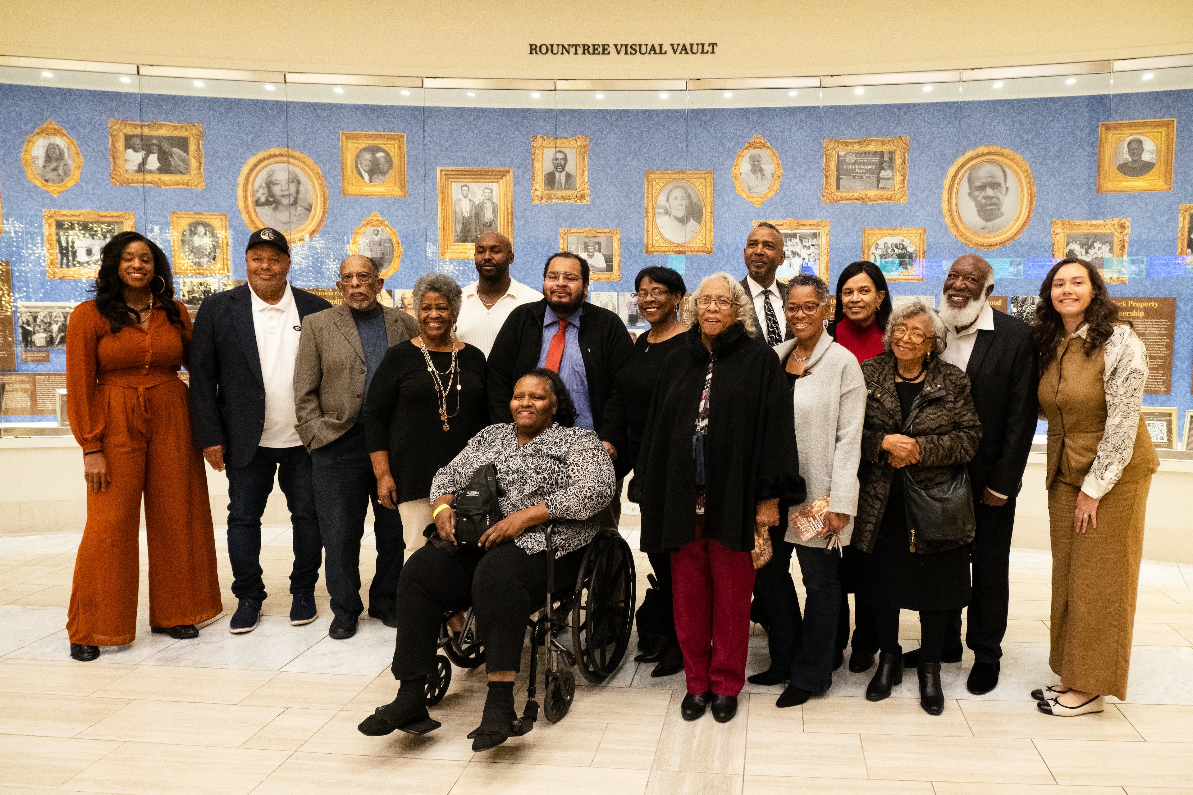 In 1912 nearly 1,000 black residents were expelled from Forsyth County. Pictured here are descendants of those expelled residents standing in front of an exhibit at Atlanta History Center that tells the stories of their relatives. In the center, wearing a black jacket, is Mattie Conley, daughter of Leola Strickland Evans.