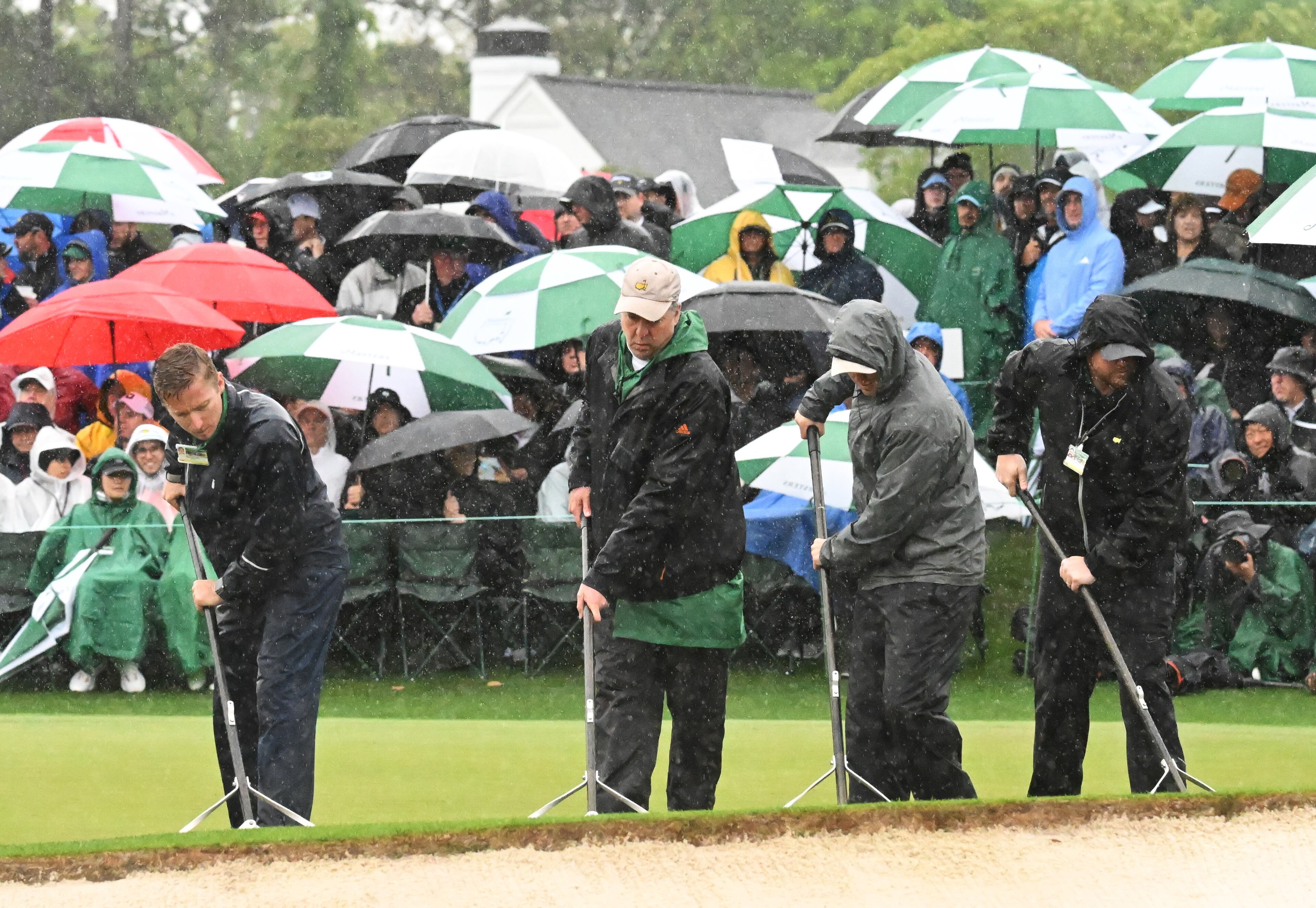 Crew clears water from 18th green during second round of the 2023 Masters Tournament at Augusta National Golf Club, Saturday, April 8, 2023, in Augusta, Ga. (Hyosub Shin / Hyosub.Shin@ajc.com)
