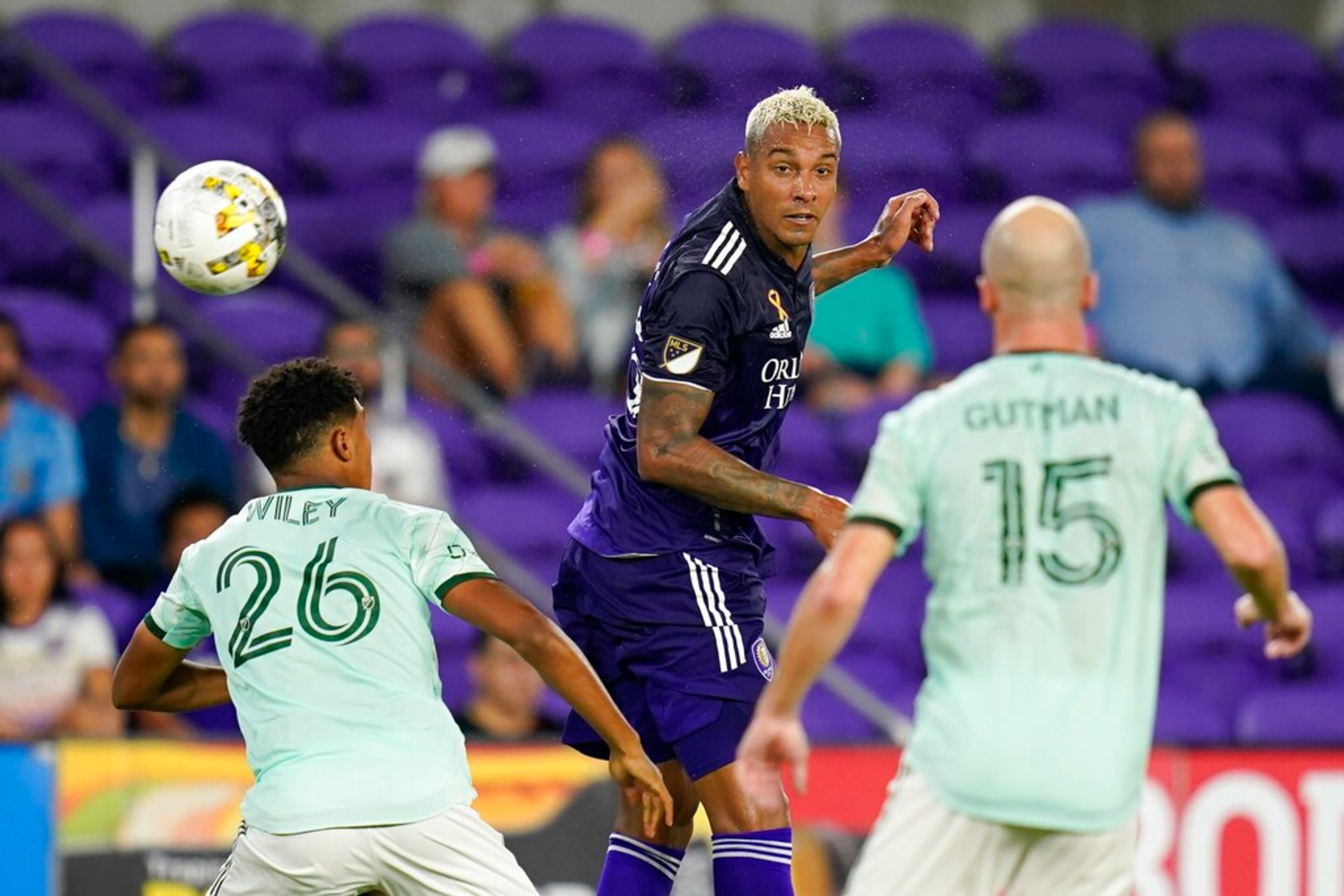 Orlando City's Antonio Carlos, center, heads the ball away from Atlanta United's Caleb Wiley (26) and Andrew Gutman (15) during the second half of an MLS soccer match Wednesday, Sept. 14, 2022, in Orlando, Fla. (AP Photo/John Raoux)