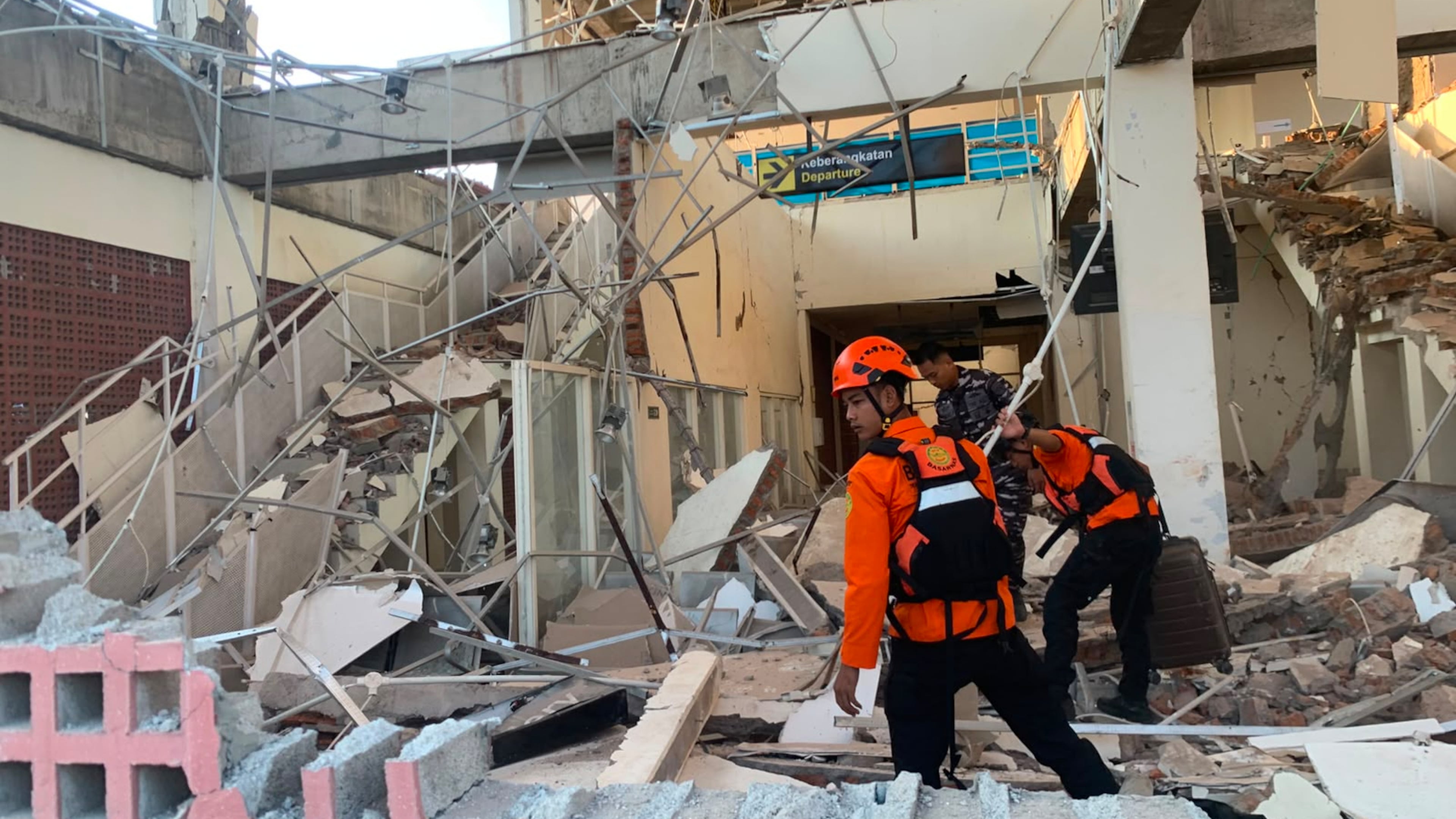 In this photo released by the Indonesian National Search and Rescue Agency (BASARNAS), rescuers search for victims at a damaged building following an earthquake in Maumere, East Nusa Tenggara Province, Indonesia, Saturday, Aug. 15, 2026. (BASARNAS via AP)