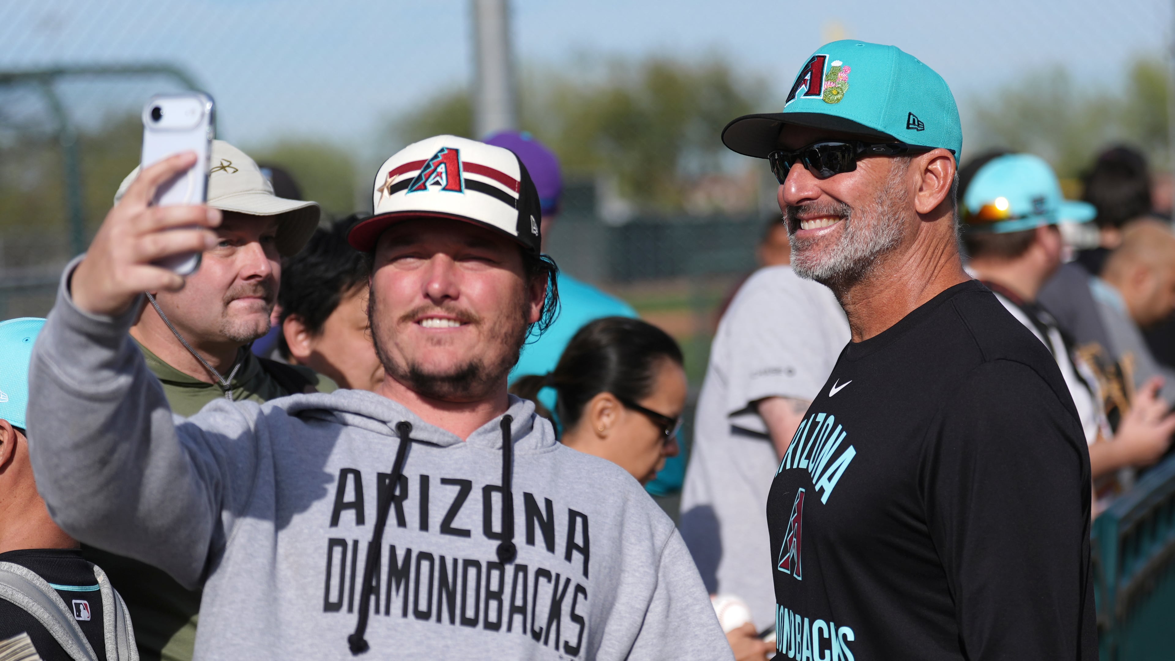 Arizona Diamondbacks manager Torey Lovullo smiles as he takes a selfie with a fan during spring training baseball Thursday, Feb. 12, 2026, in Scottsdale, Ariz. (AP Photo/Ross D. Franklin)