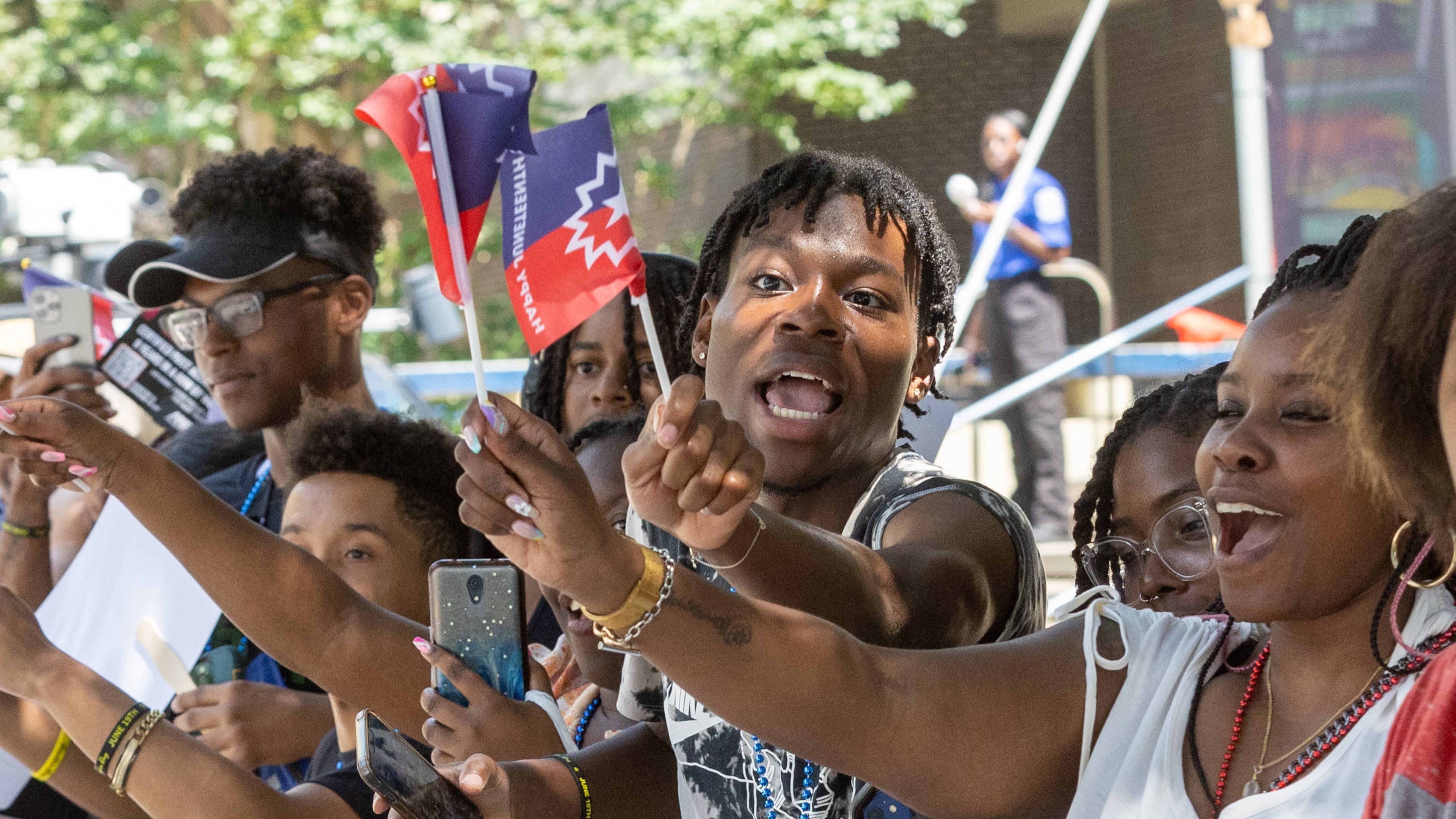 Chauncey Delaney (Center) cheers on the parade as it moves up Decatur St towards Centennial Park during the Juneteenth Atlanta Parade and Music Festival Saturday, June 17, 2023. (Steve Schaefer/steve.schaefer@ajc.com)