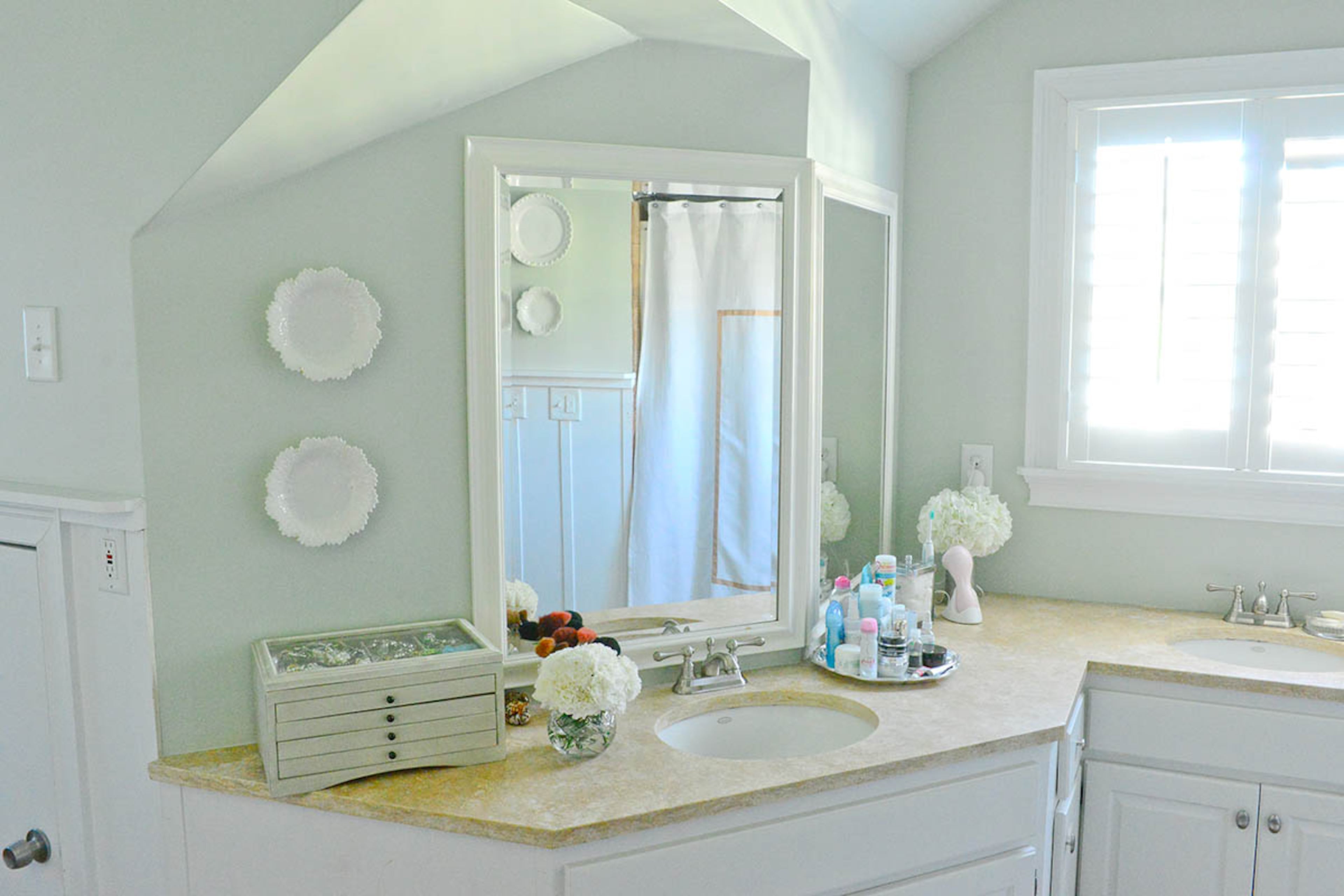 Katie Luepke loves that from the outside, her home doesn't look big enough to sport such a large master bathroom. But it has a shower and a jacuzzi bath. The white plates, mostly found at HomeGoods, give the room an almost-cottage charm.