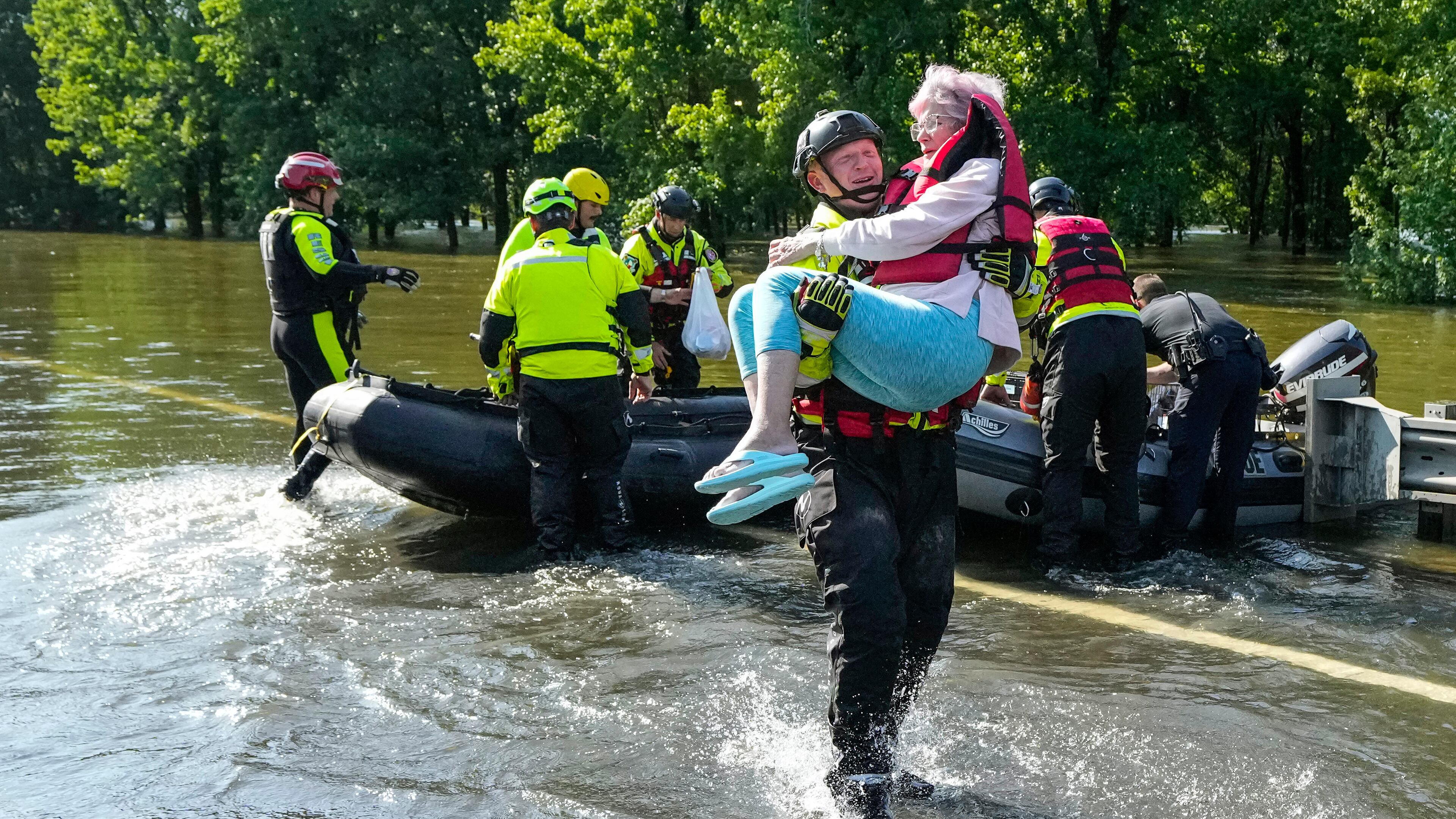FILE - Conroe firefighter Cody Leroy carries a resident evacuated in a boat by the CFD Rapid Intervention Team from her flooded home in the aftermath of a severe storm May 2, 2024, in Conroe, Texas. (Brett Coomer/Houston Chronicle via AP)