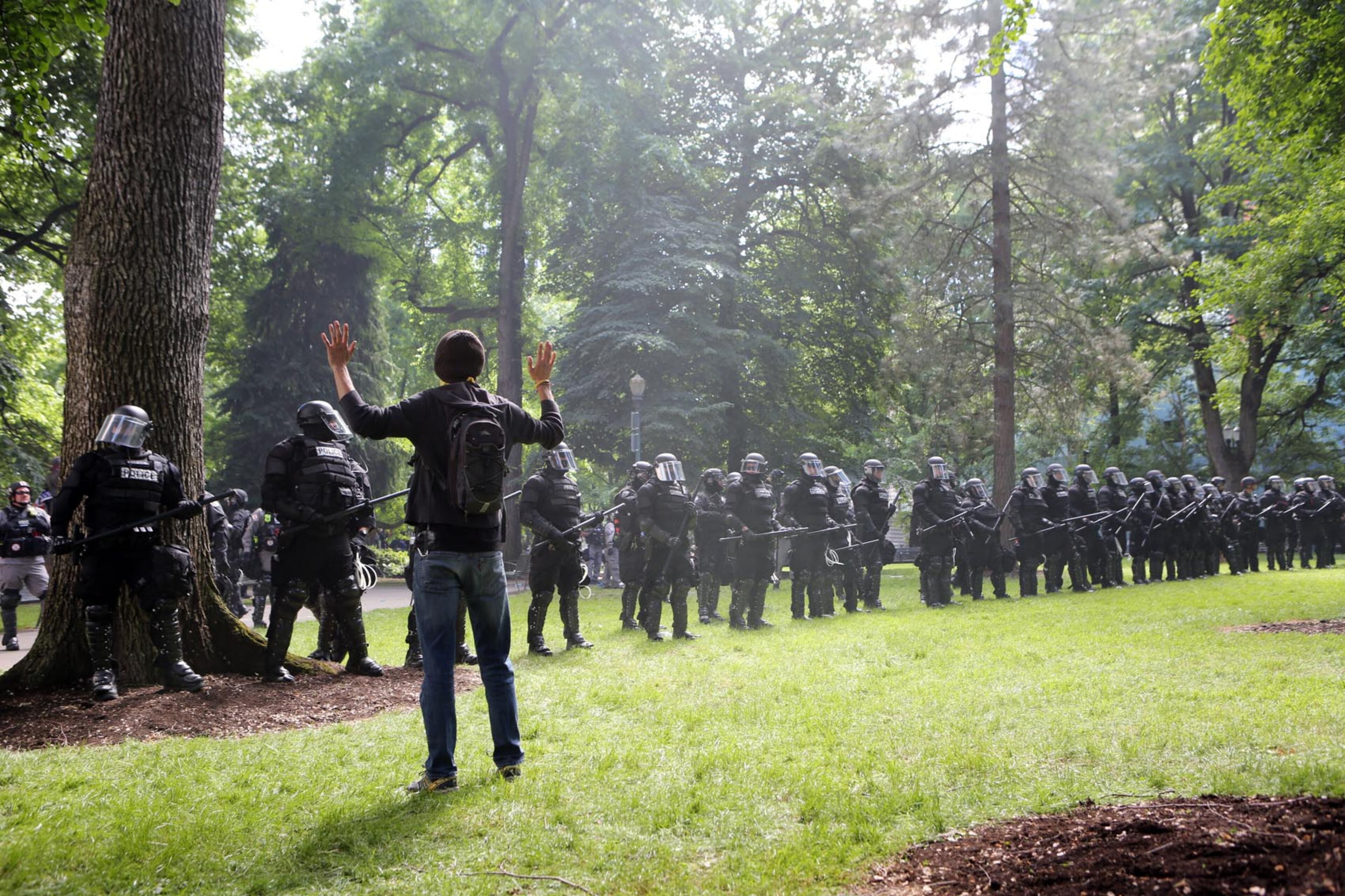 PORTLAND, OR - JUNE 04: A Left wing 'Antifa' protester holds up his hands as police seek to clear a park at a rally on June 4, 2017 in Portland, Oregon. A protest dubbed 'Trump Free Speech' by organizers was met by a large contingent of counter-demonstrators who viewed the protest as a promotion of racism. The demonstrations come in the wake of the recent violent attack on the city's MAX train line when Ricky Best, 53, and Taliesin Namkai-Meche, 23, were stabbed to death and Micah Fletcher,21, was severely injured after they tried to protect two teenage girls, one of whom was wearing a hijab, from being harassed with racial taunts by suspect Jeremy Christian. (Photo by Natalie Behring/Getty Images)