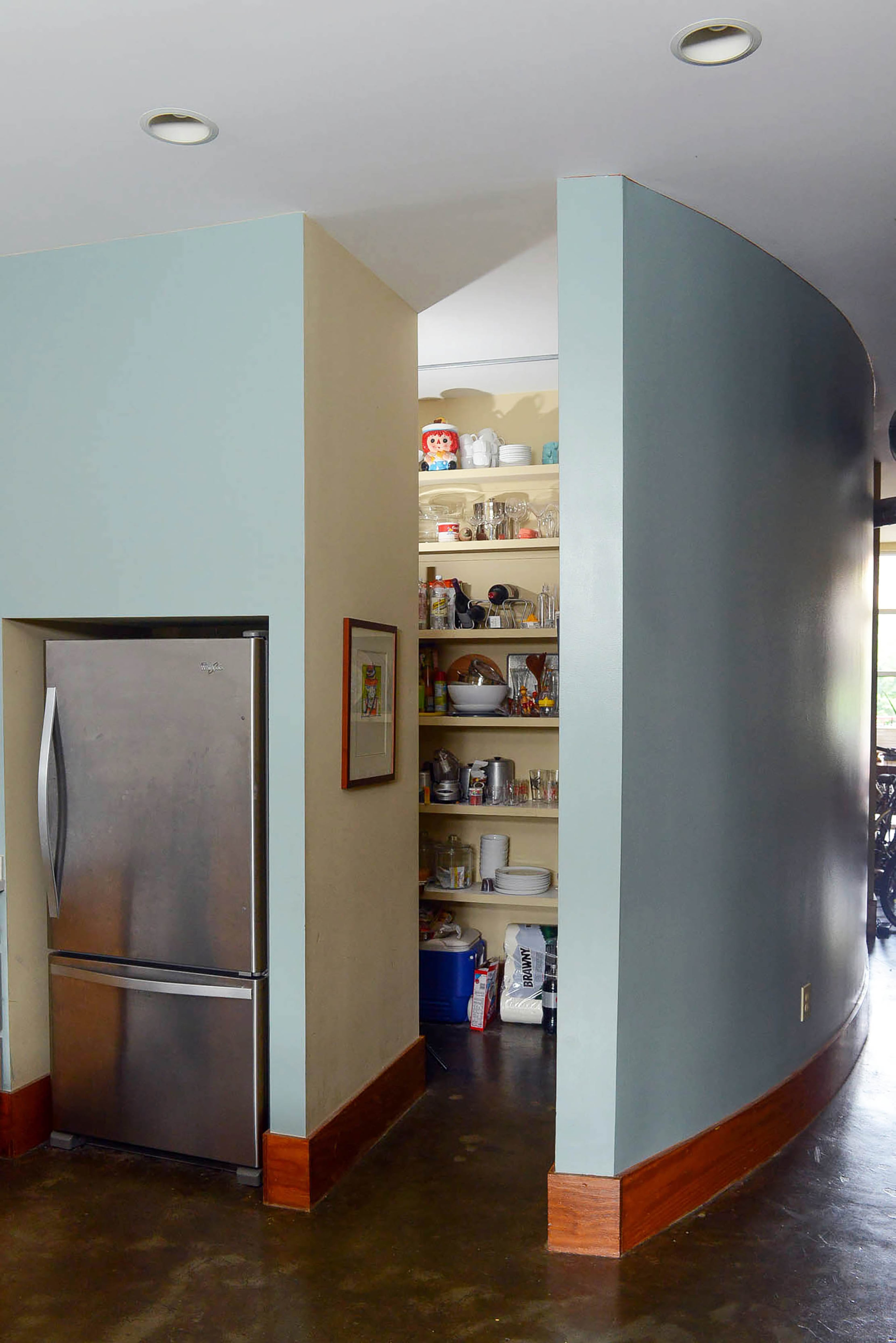 An accent wall rounds the pantry space in the kitchen. The interesting architecture is because the loft was a warehouse in the 1950s