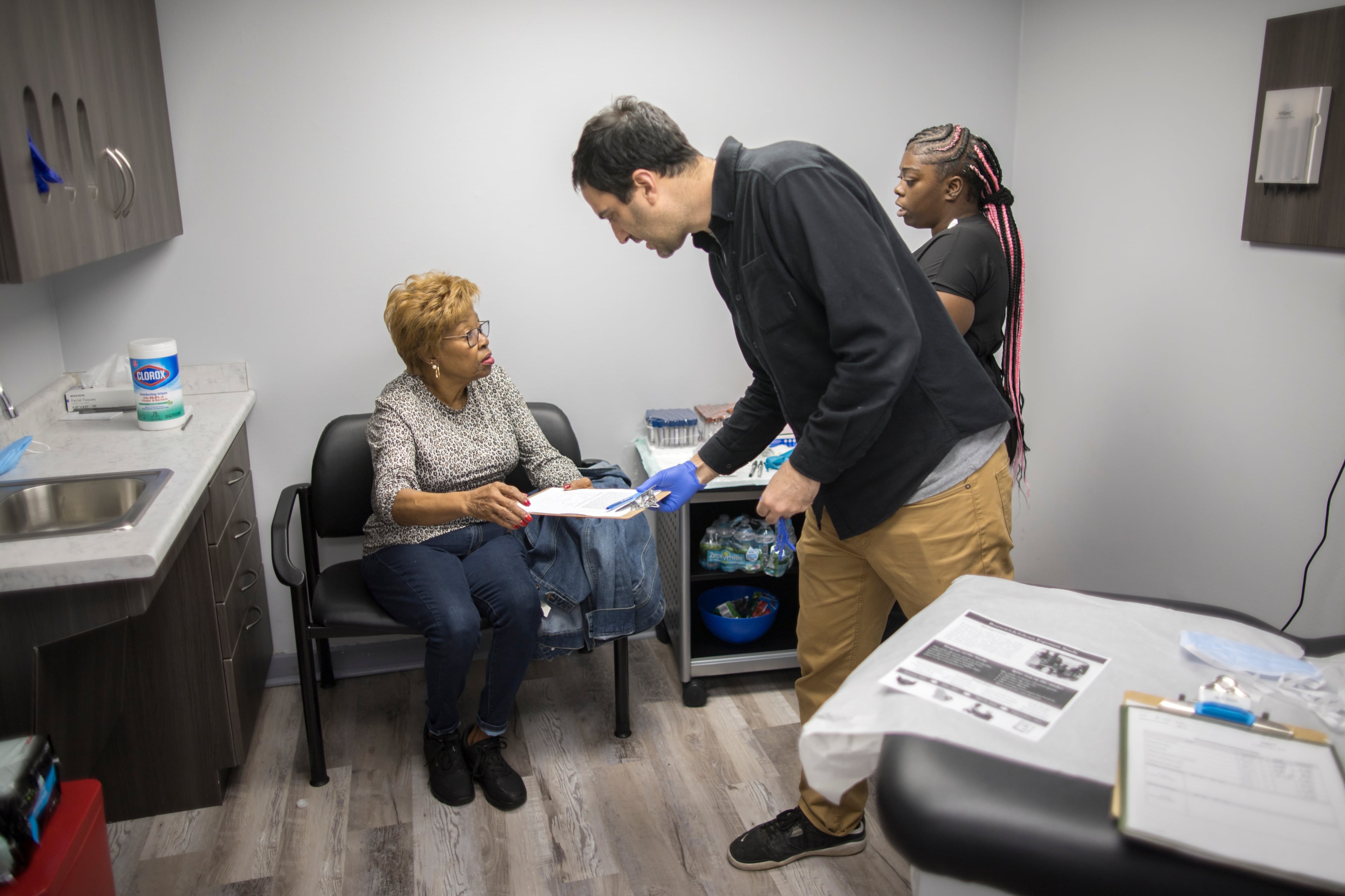 Noah Scovronick, center, assistant professor at Emory University's Rollins School of Public Health, goes over a form with study participant and Brunswick resident, Etta Brown, left, before she gives a blood sample. The Emory team is investigating the population's exposure to some of the chemicals present around the Brunswick area. (AJC Photo/Stephen B. Morton)