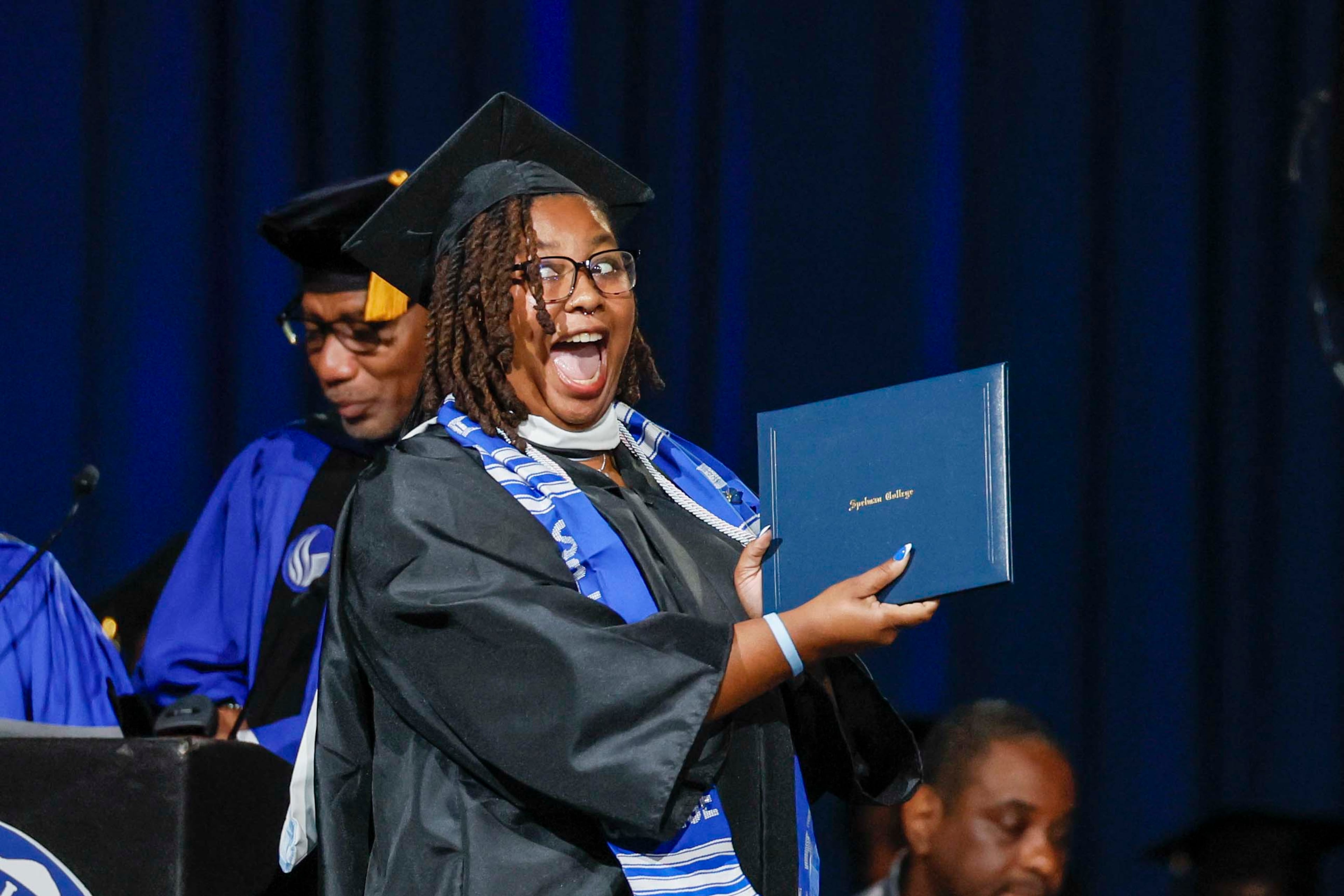 A graduate reacts after receiving her diploma during the Spelman College Commencement at the Georgia International Convention Center in College Park on Sunday, May 17, 2026. (Miguel Martinez/AJC)