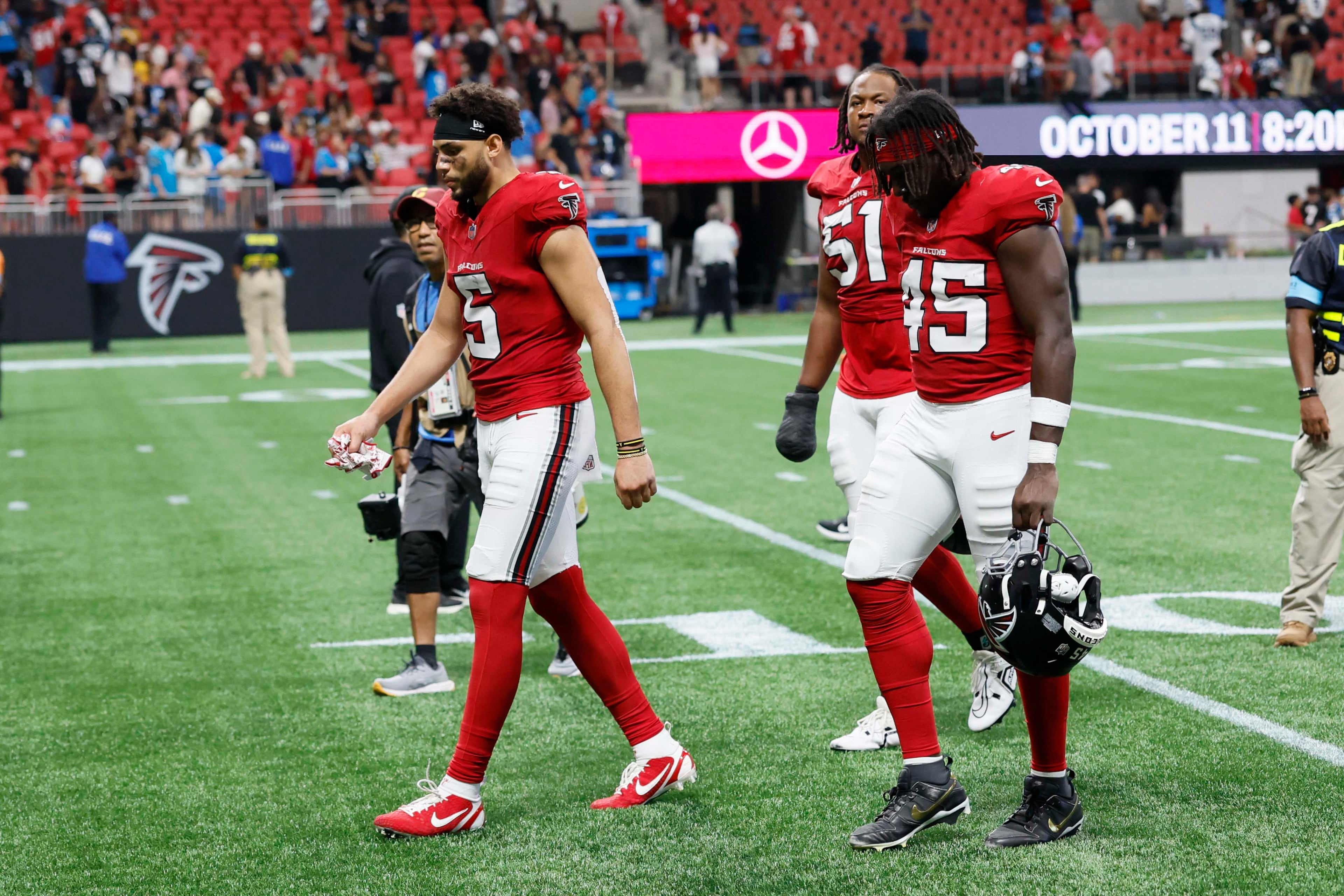 Atlanta Falcons wide receiver Drake London (5) and Atlanta Falcons linebacker Christian Harris (45) walk with their heads down as they leave the field after losing 34-3 to the Carolina Panthers at Mercedes-Benz Stadium in Atlanta on Sunday, Sept. 20, 2026. (Miguel Martinez/AJC)