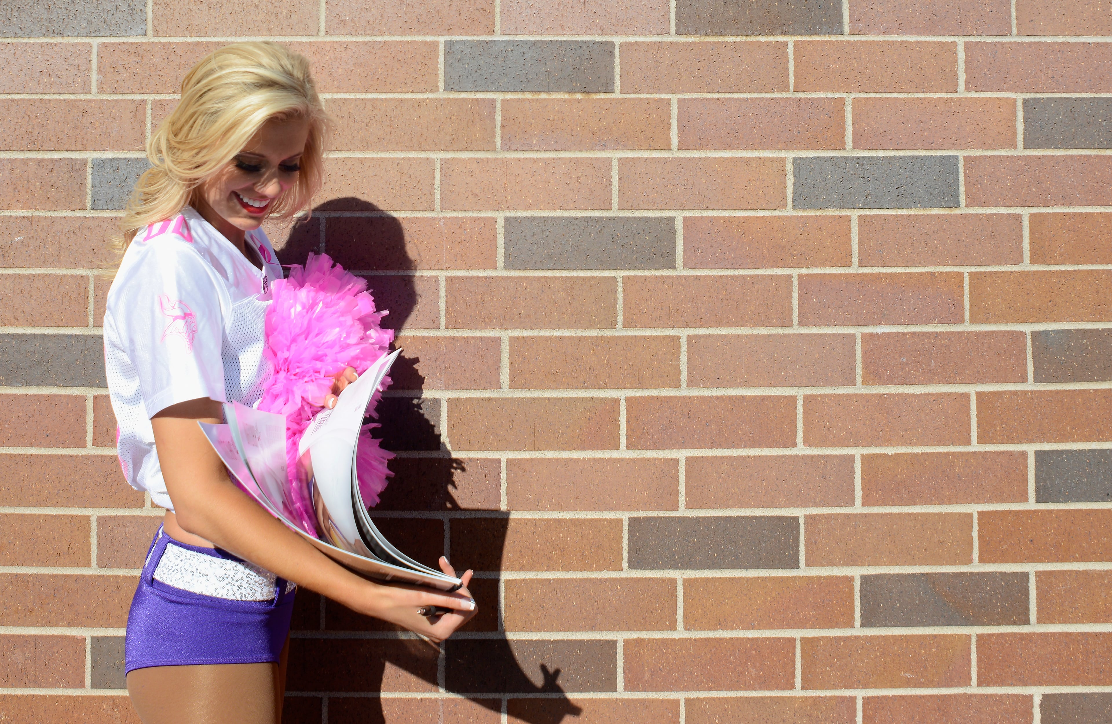 MINNEAPOLIS, MN - OCTOBER 18: A cheerleader signs an autograph during the third quarter of the game between the Minnesota Vikings and the Kansas City Chiefs on October 18, 2015 at TCF Bank Stadium in Minneapolis, Minnesota. The Vikings defeated the Chiefs 16-10. (Photo by Hannah Foslien/Getty Images)