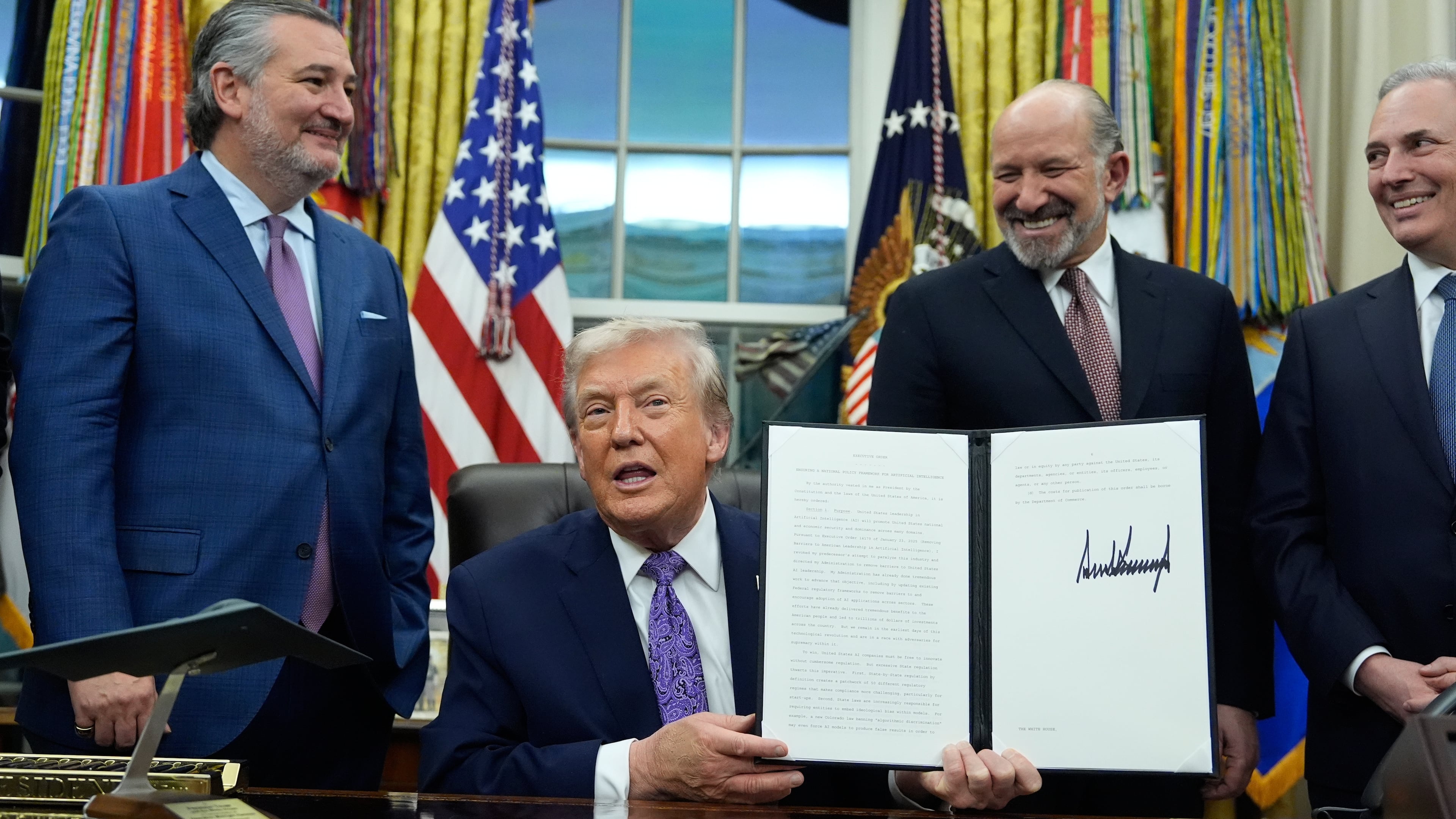 FILE - Flanked by Sen. Ted Cruz, R-Texas, left, Secretary of Commerce Howard Lutnick, second right, and White House AI and Crypto Czar David Sacks, President Donald Trump displays his signed AI initiative in the Oval Office of the White House, Dec. 11, 2025, in Washington. (AP Photo/Alex Brandon, File)