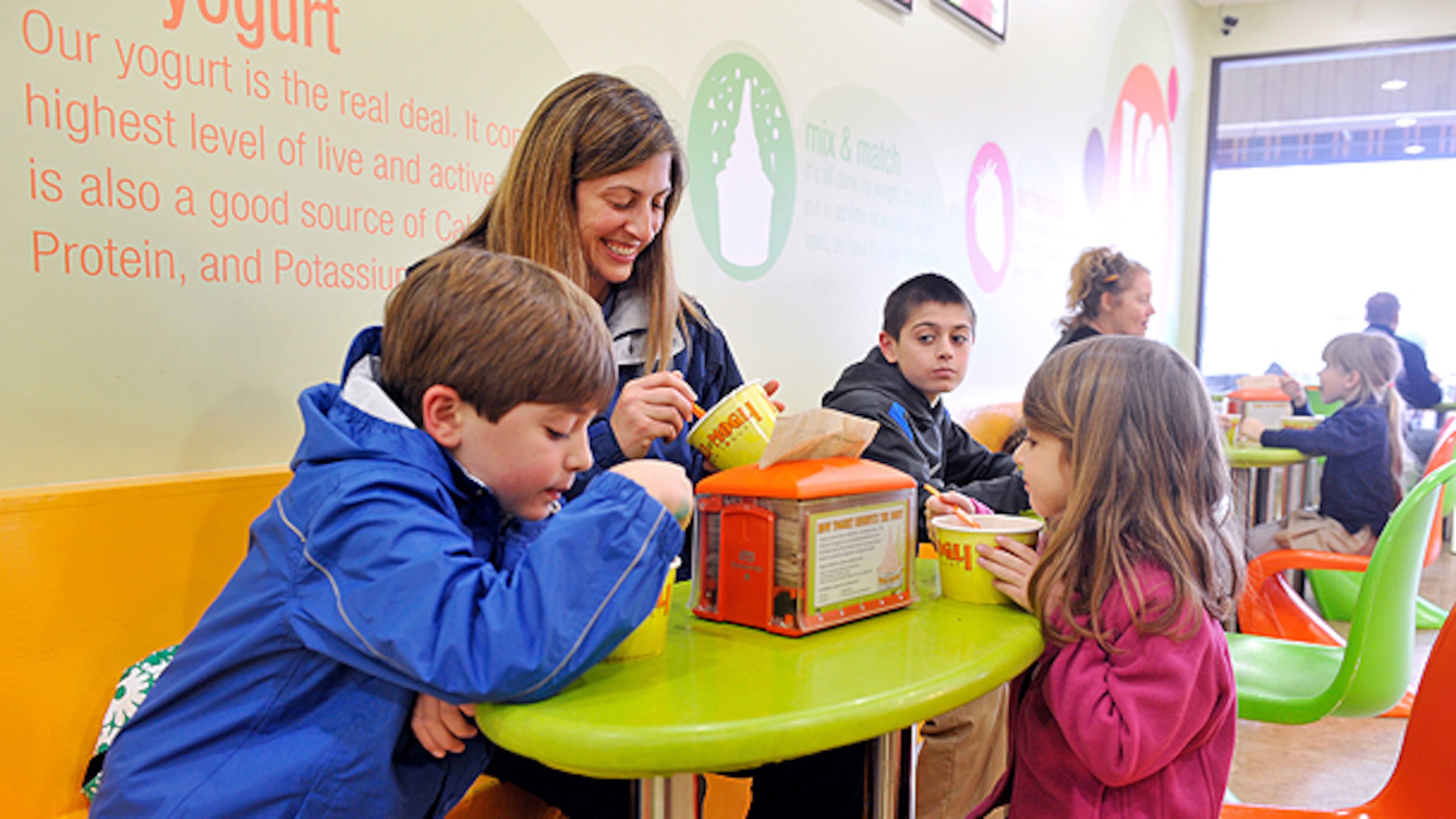 (From left) Grant Terry, 7, mother Randi Terry, brother Kyle Terry, 10, and sister Brooke Terry, 4, enjoy frozen yogurt at the East Cobb Yogli Mogli in Marietta.