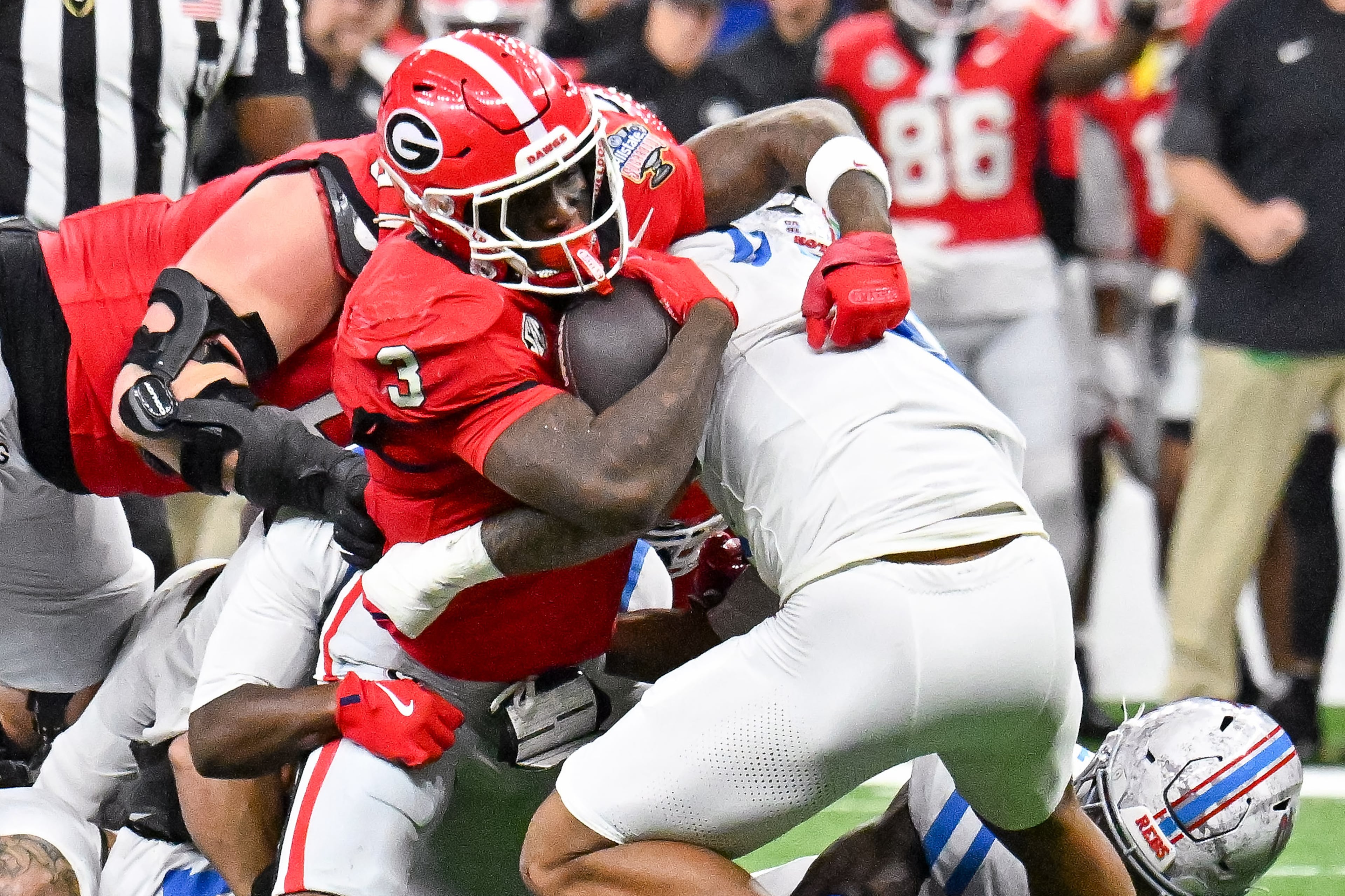 Georgia Bulldogs running back Nate Frazier (3) drives for a first down against the Ole Miss Rebels defense during the first half of the NCAA College Football Playoff quarterfinal game at the Sugar Bowl in the Caesars Superdome, Thursday, Jan. 1, 2026, in New Orleans. (Hyosub/AJC)