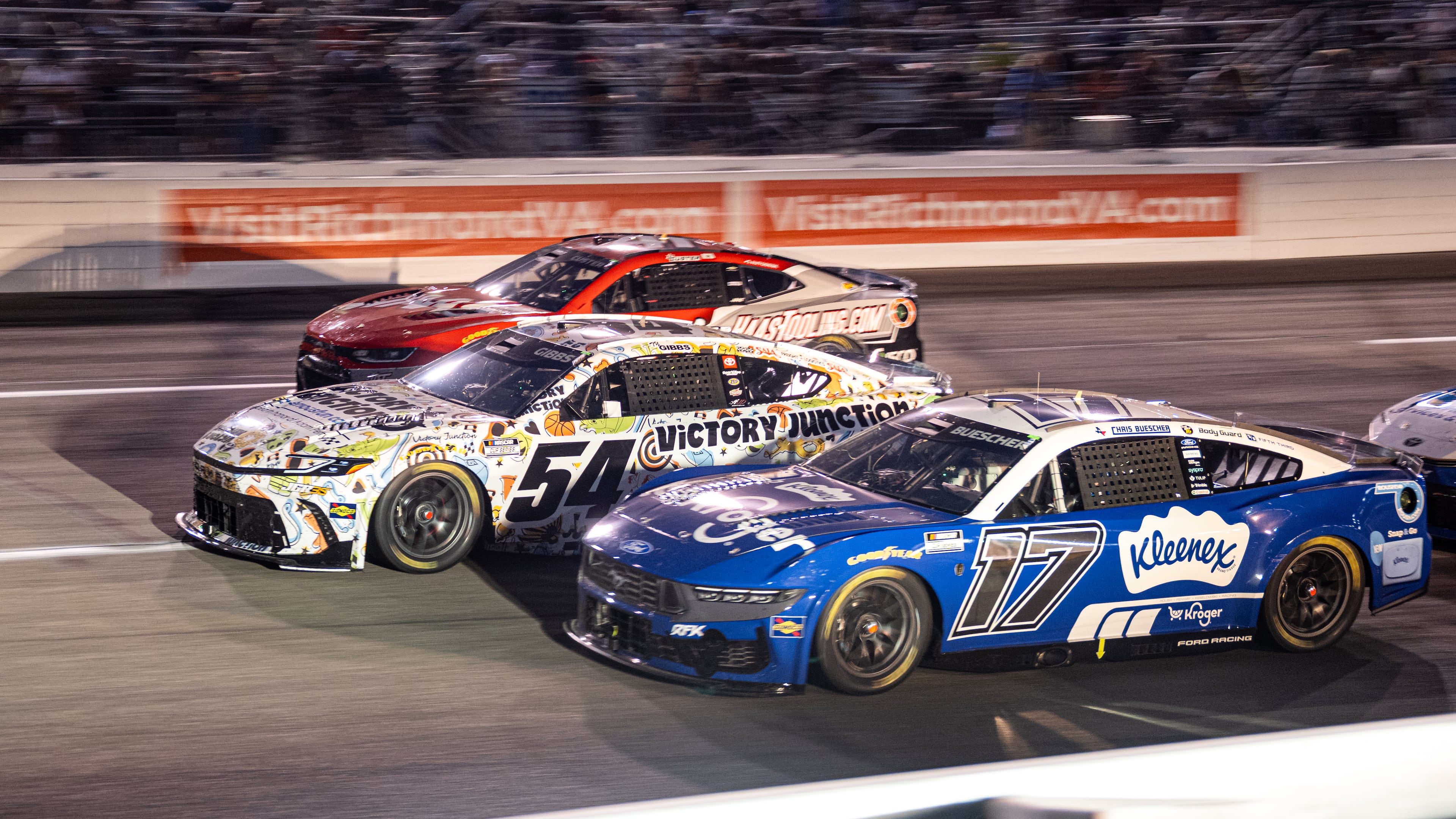 Roush Fenway Keselowski Racing driver Chris Buescher (17) and Joe Gibbs Racing driver Ty Gibbs (54) battle in turn one during Cook Out 400 at Richmond Raceway, Saturday, Aug. 15, 2026, in Richmond Va. (AP Photo/Robert Simmons)