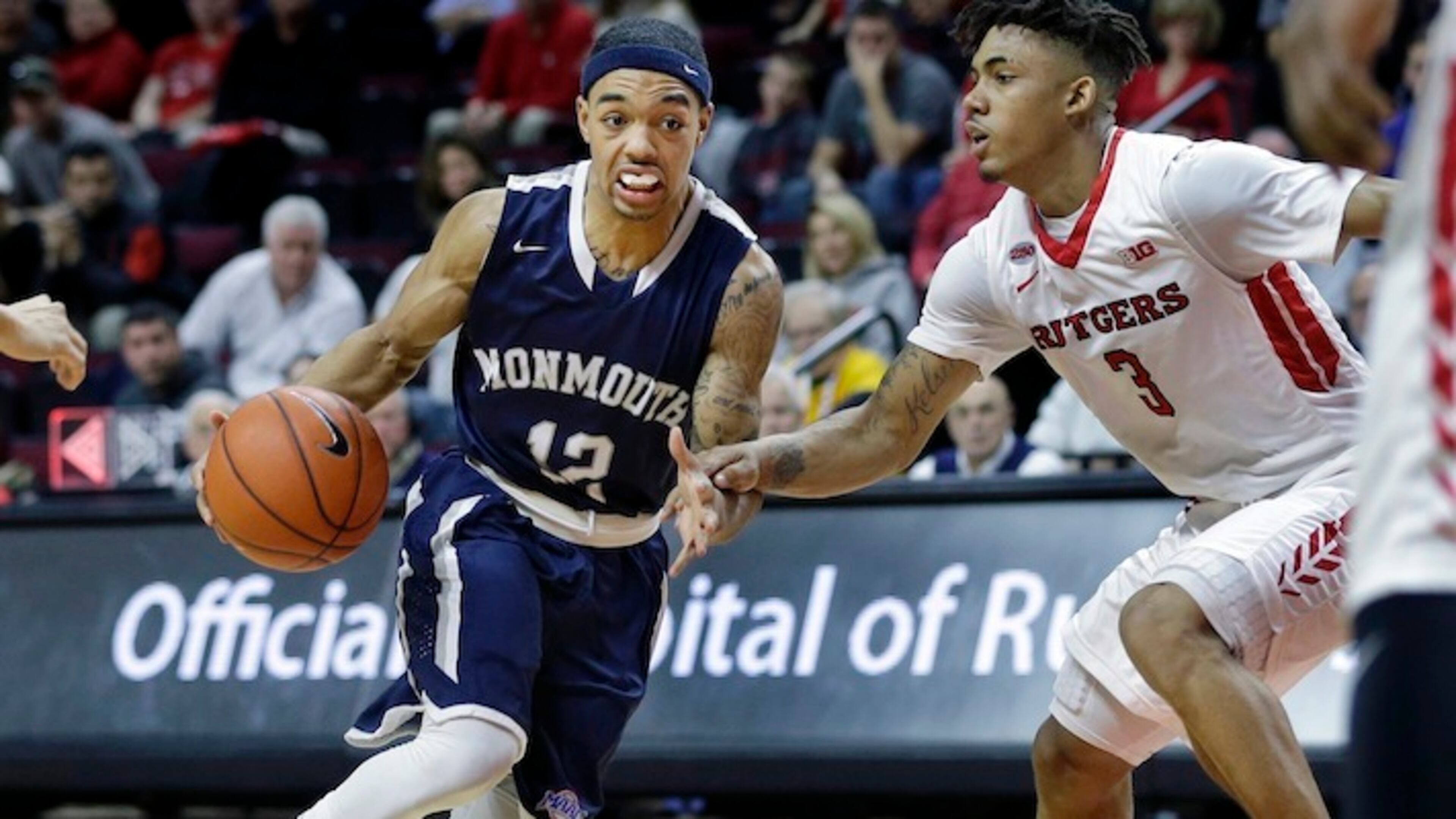 FILE - In this Sunday, Dec. 20, 2015, file photograph, Monmouth guard Justin Robinson (12) dribbles the ball as Rutgers guard Corey Sanders (3) tries to block his path during an NCAA college basketball game in Piscataway, N.J. Robinson is 26th in the nation and third in the MAAC with a 20.3 scoring average. He is seventh in the MAAC in assists (3.8). Monmouth (22-5) has set a school record for victories, leads the conference at 14-2 and has an RPI of 35 after four wins over power conference teams in November and December. (AP Photo/Mel Evans, File)