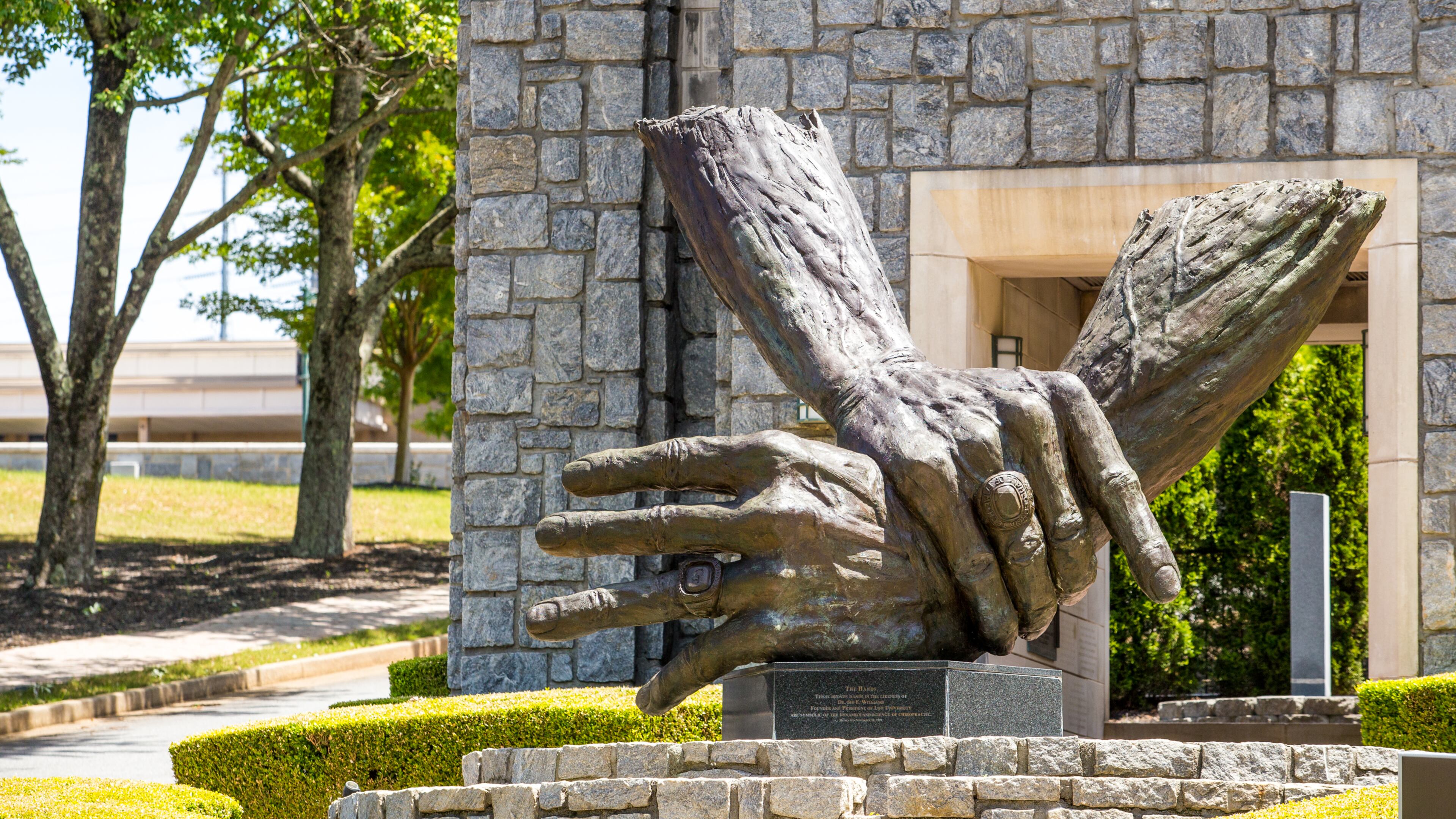 At Marietta's Life University, the nation's largest chiropractic school, a traditional, philosophy-based form of chiropractic dominates, promoting spinal adjustments and healthy living as the best protections against disease. Seen here is the campus's sculpture of the hands of founder Sid Williams. (Jenni Girtman for The Atlanta Journal Constitution)