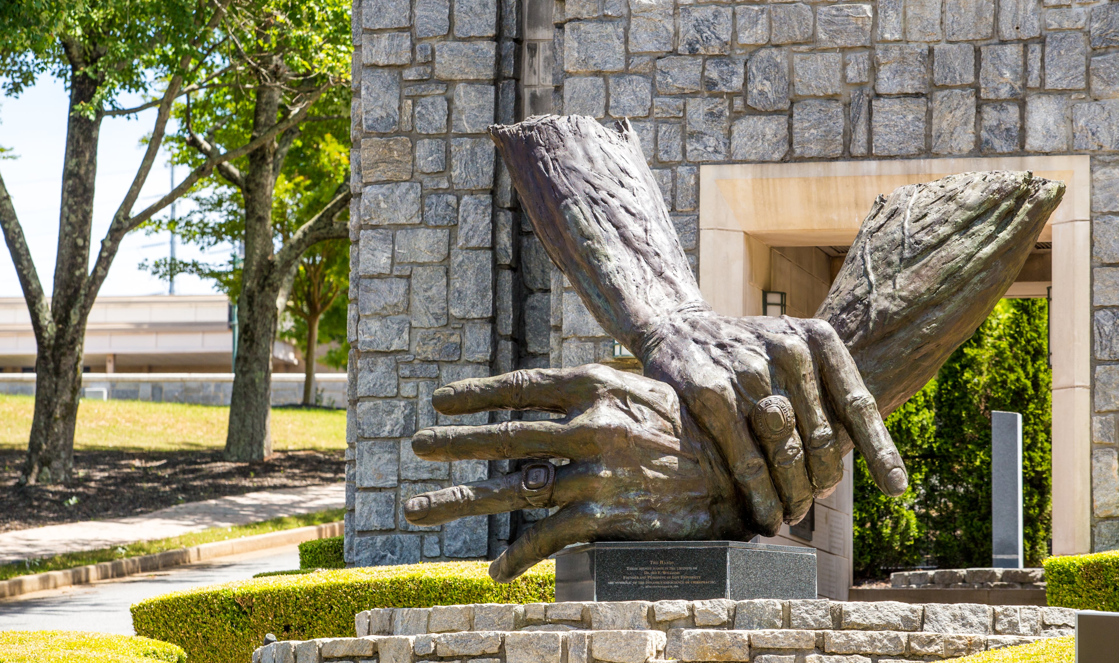 At Marietta's Life University, the nation's largest chiropractic school, a traditional, philosophy-based form of chiropractic dominates. This campus sculpture is of the hands of founder Sid Williams. (Jenni Girtman for the AJC)