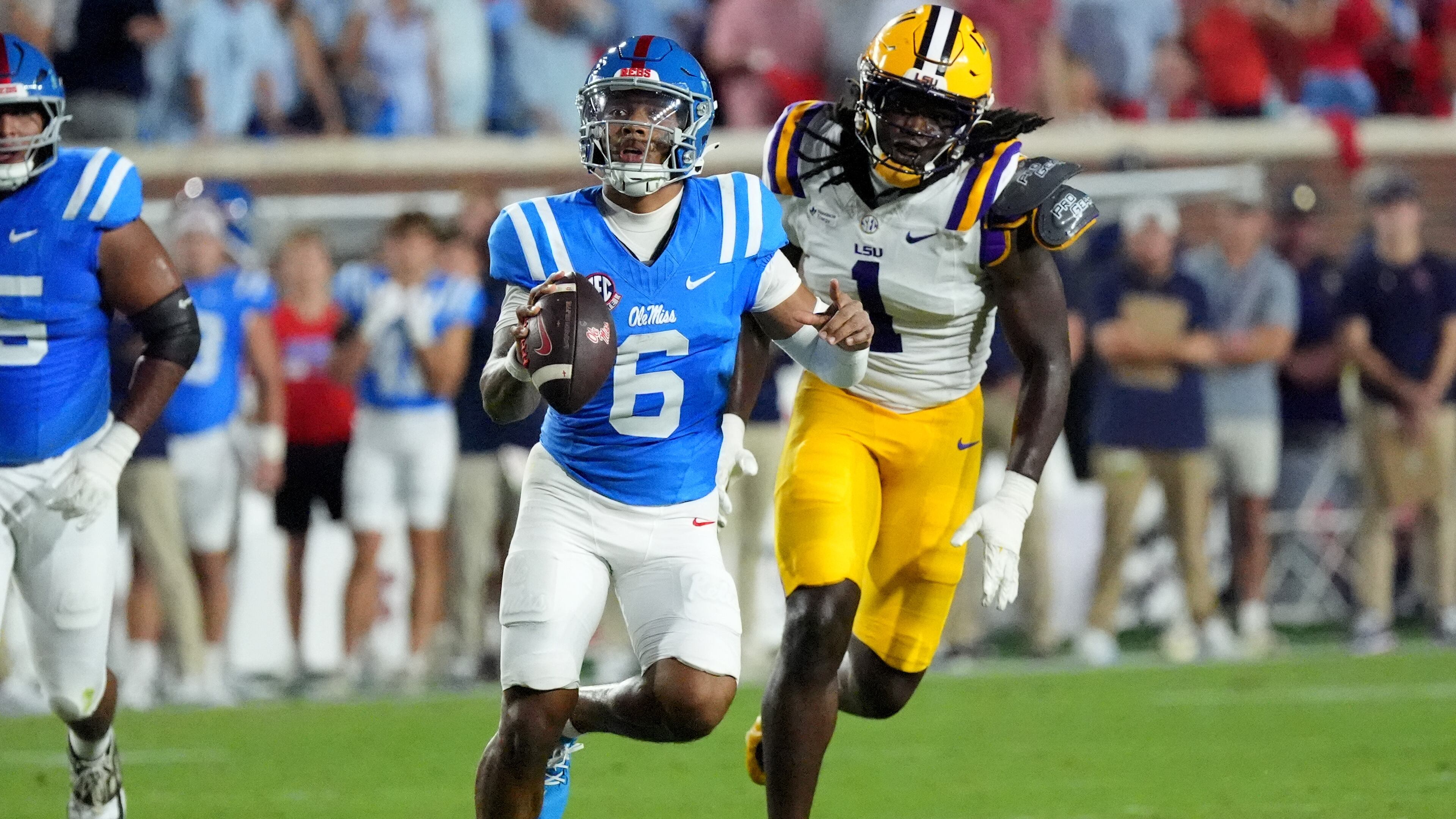 Mississippi quarterback Trinidad Chambliss (6) is pursued by LSU defensive end Princewill Umanmielen (1) during the first half of an NCAA college football game in Oxford, Miss., Saturday, Sept. 19, 2026. (AP Photo/Rogelio V. Solis)
