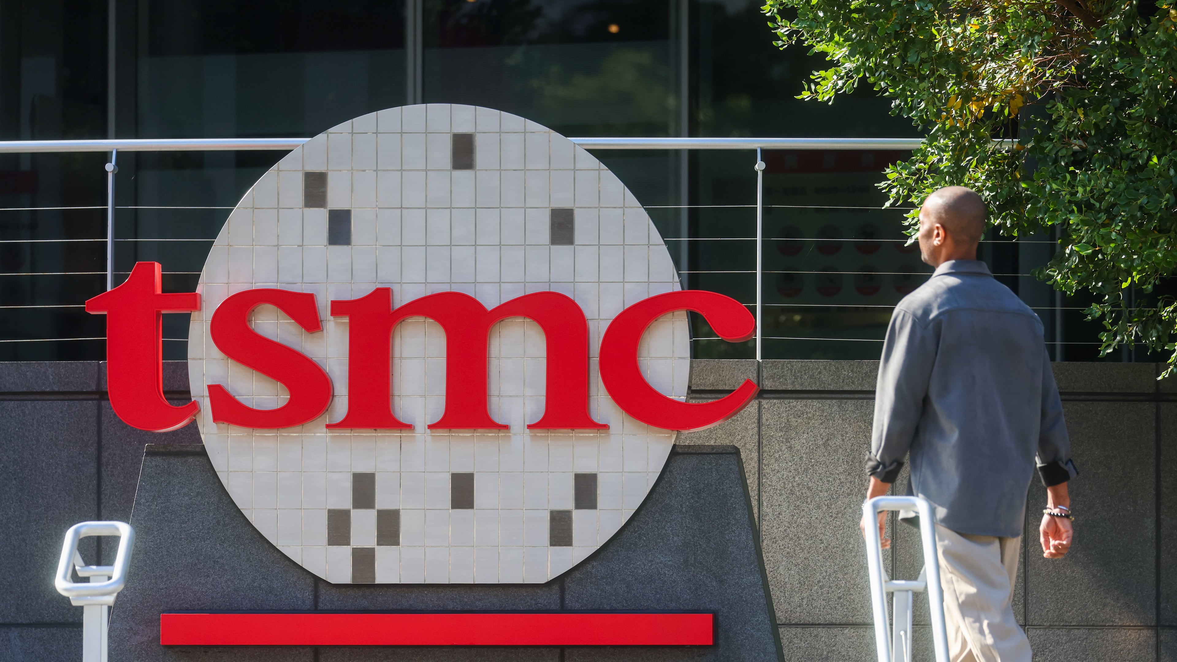 FILE - A worker walks past the logo of TSMC or Taiwan Semiconductor Manufacturing Corp., a Taiwanese multinational semiconductor contract manufacturing and design company, in Hsinchu, Taiwan, on Jan. 29, 2026. (AP Photo/Daniel Ceng, File)