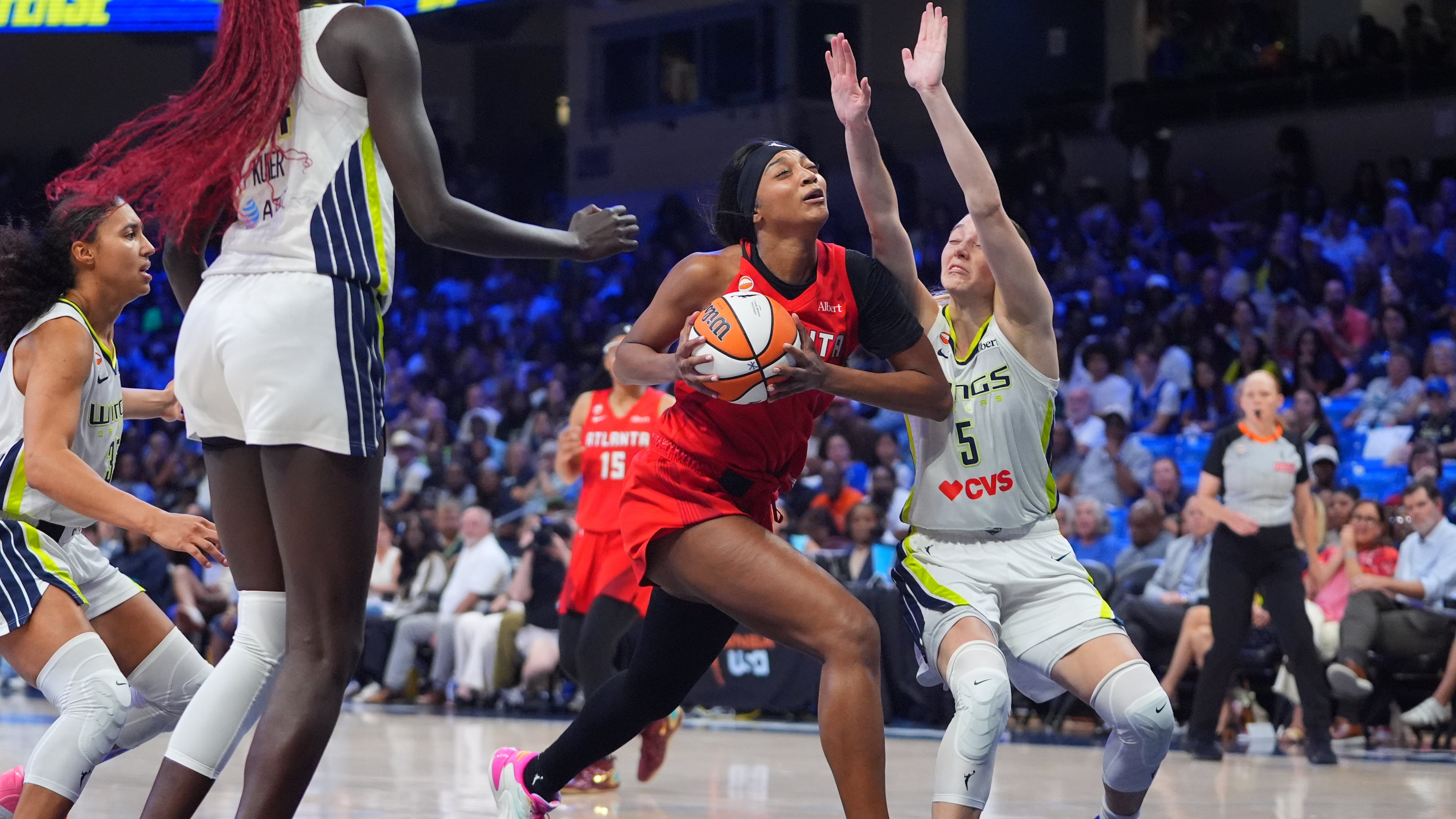 Atlanta Dream forward Angel Reese, center, drives against Dallas Wings guard Paige Bueckers (5) during the second half of a WNBA basketball game in Arlington, Texas, Wednesday, July 29, 2026. (AP Photo/LM Otero)