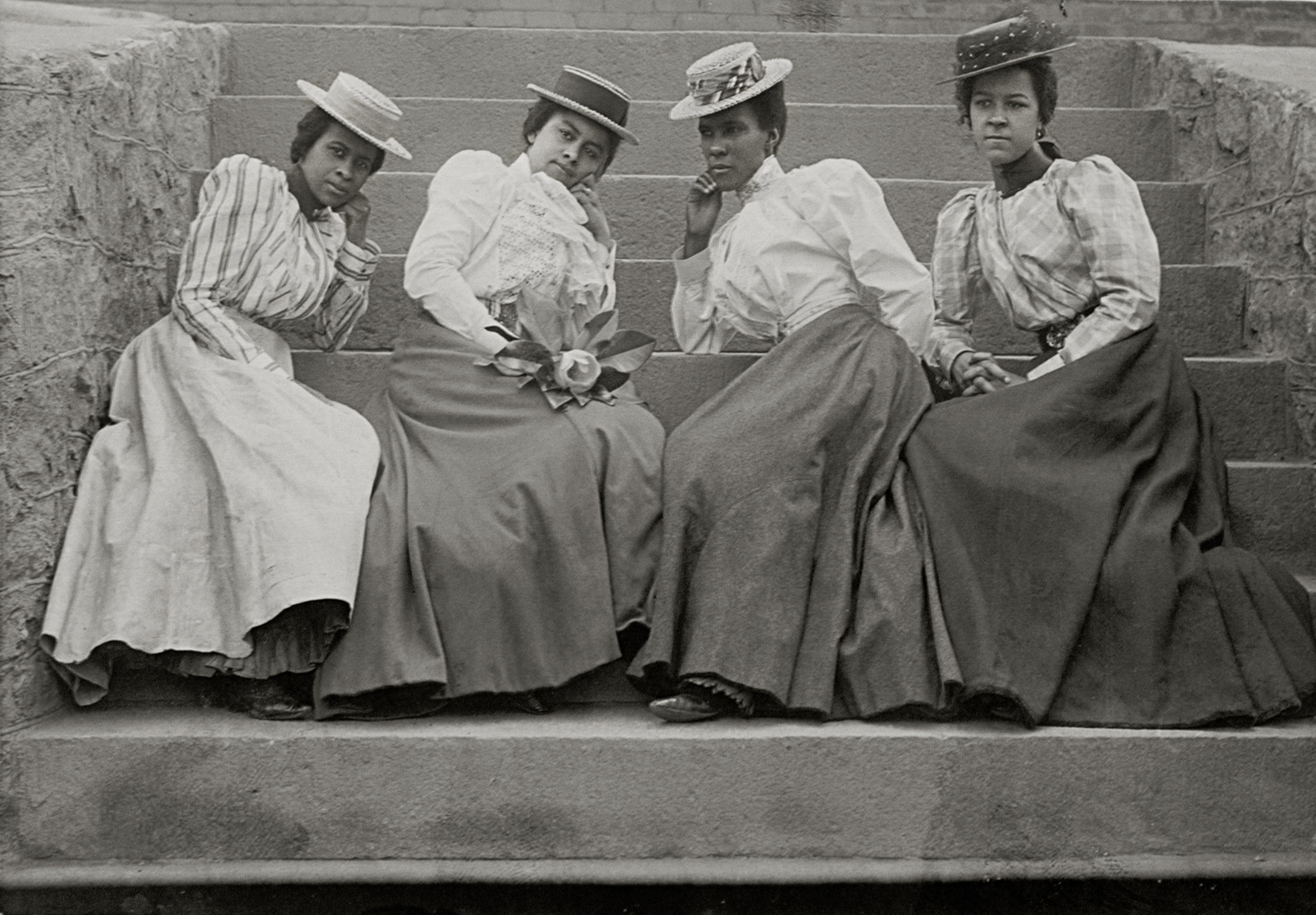 Considered the first African-American photographer in Atlanta, a representation of Thomas Askew's images of the city's prosperous African-American residents like "Four African American Women Seated on Steps of Building at Atlanta University, Georgia" from 1899 or 1900 are included in the exhibition "Posing Beauty."