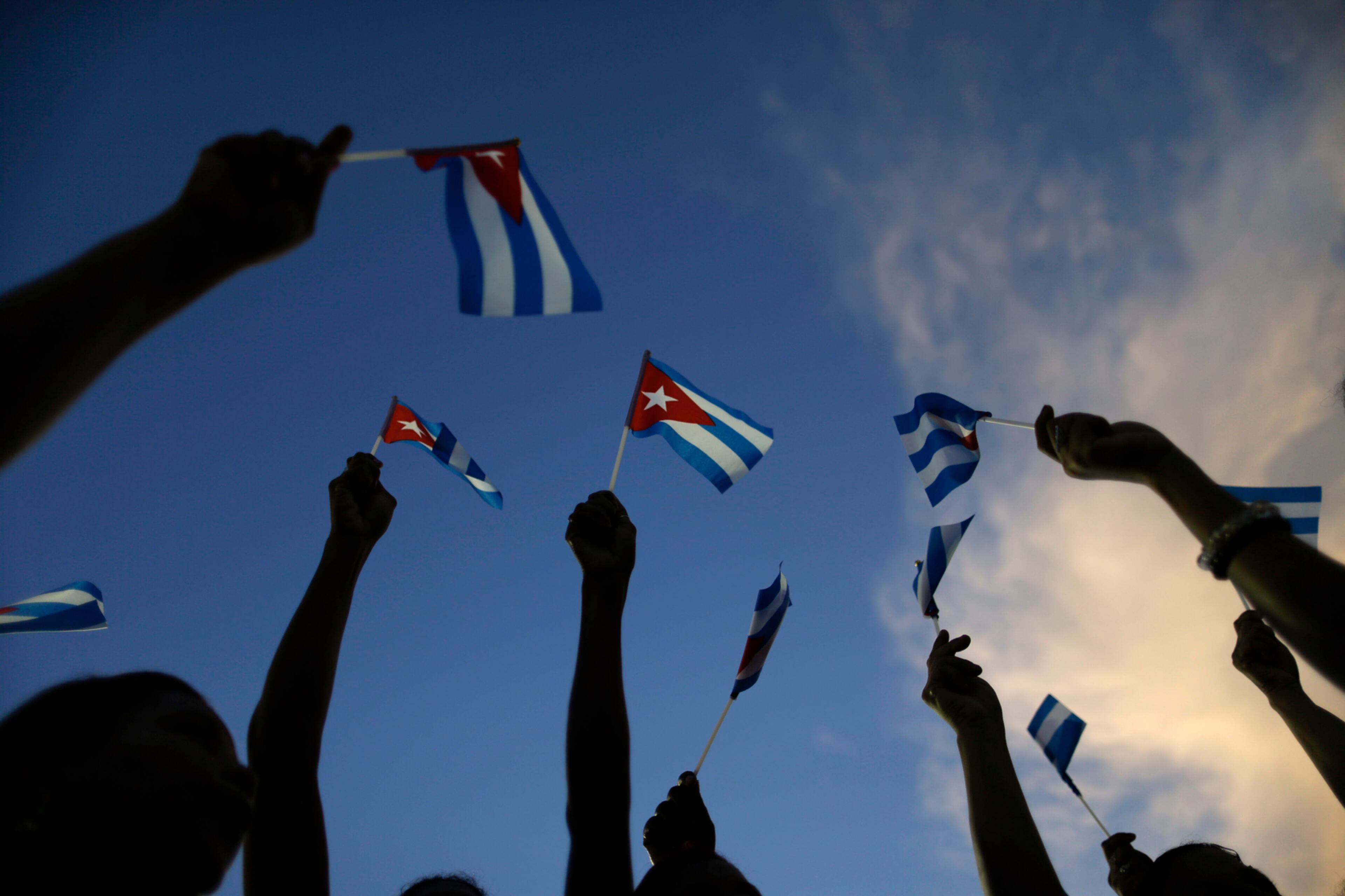 People wave Cuban flags before a rally honoring the late Fidel Castro at Antonio Maceo plaza in Santiago, Cuba, Saturday, Dec. 3, 2016. After a four-day journey across the country through small towns and cities where his rebel army fought its way to power nearly 60 years ago, Castro's remains arrived Saturday to Santiago where they will be buried the following day. (AP Photo/Natacha Pisarenko)