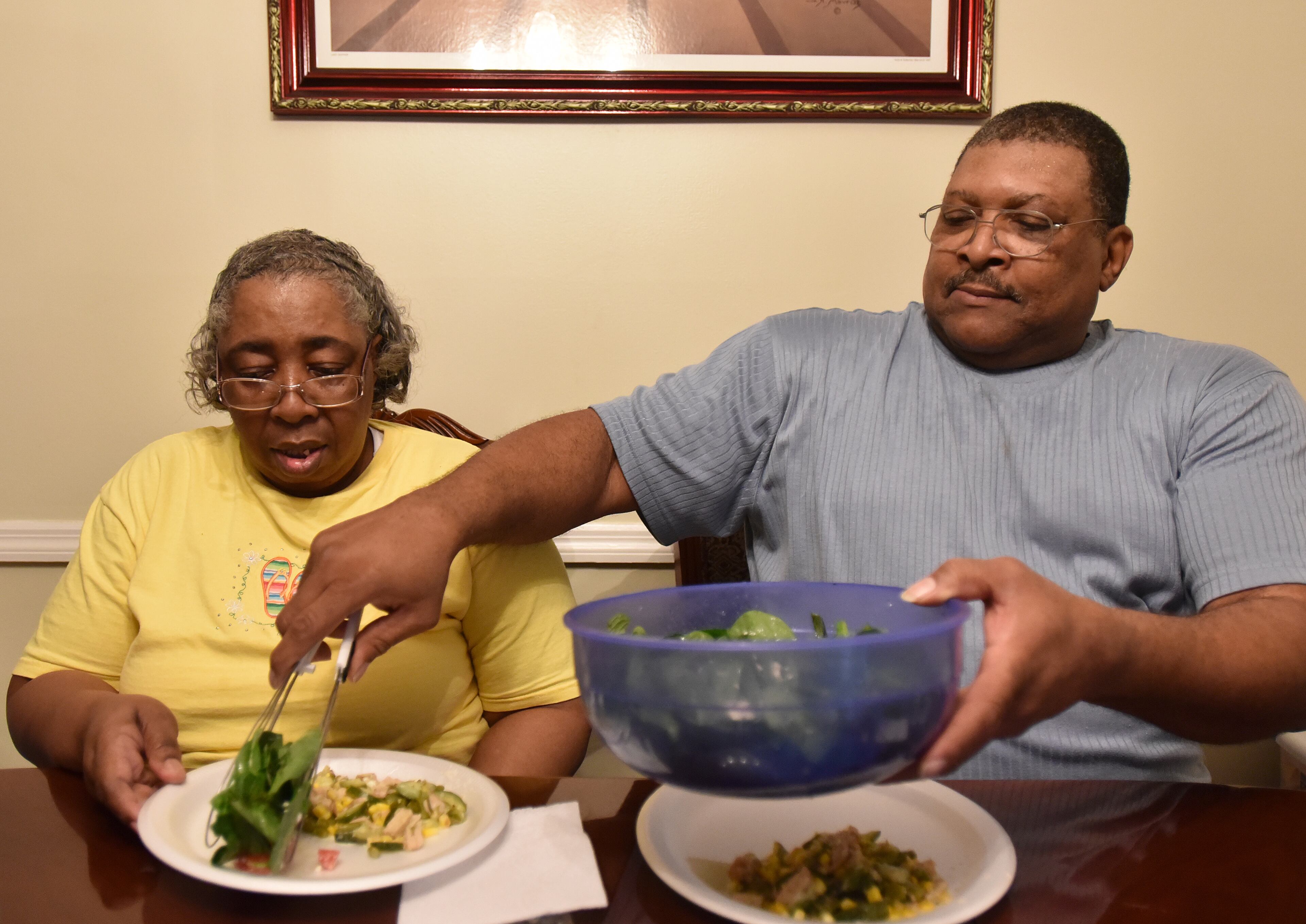 Lavern Evans serves dinner to his wife Bonita at their home in College Park. HYOSUB SHIN / HSHIN@AJC.COM