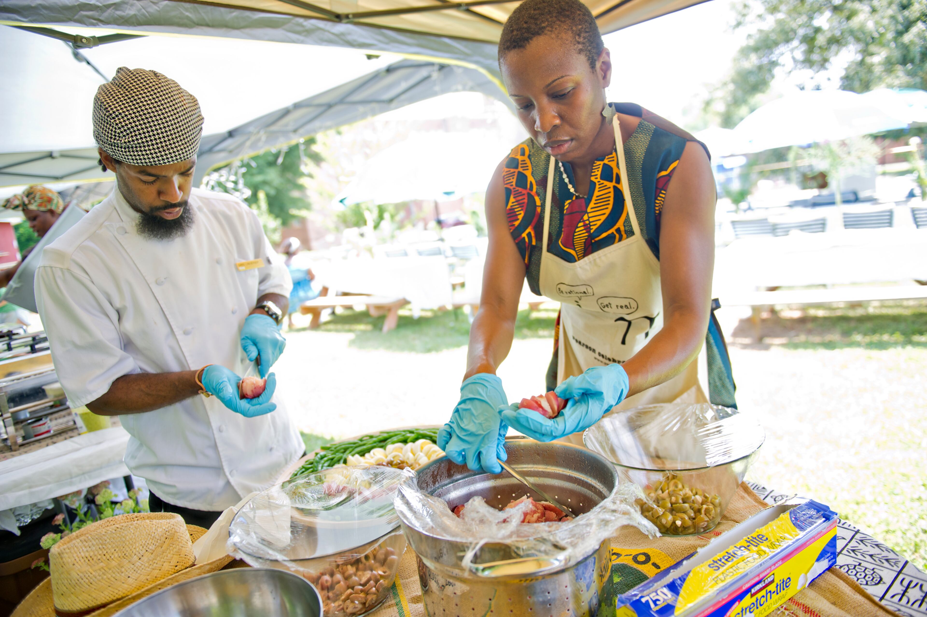 Chefs Chris Lineberger (left) and Natasha Brewley put the finishing touches on lunch during the Patchwork City Farms' Father's Day Farm Fete in Atlanta on Sunday, June 15, 2014. Around 150 fathers and families were treated to lunch, live music, field day games and garden tours for Father's Day.