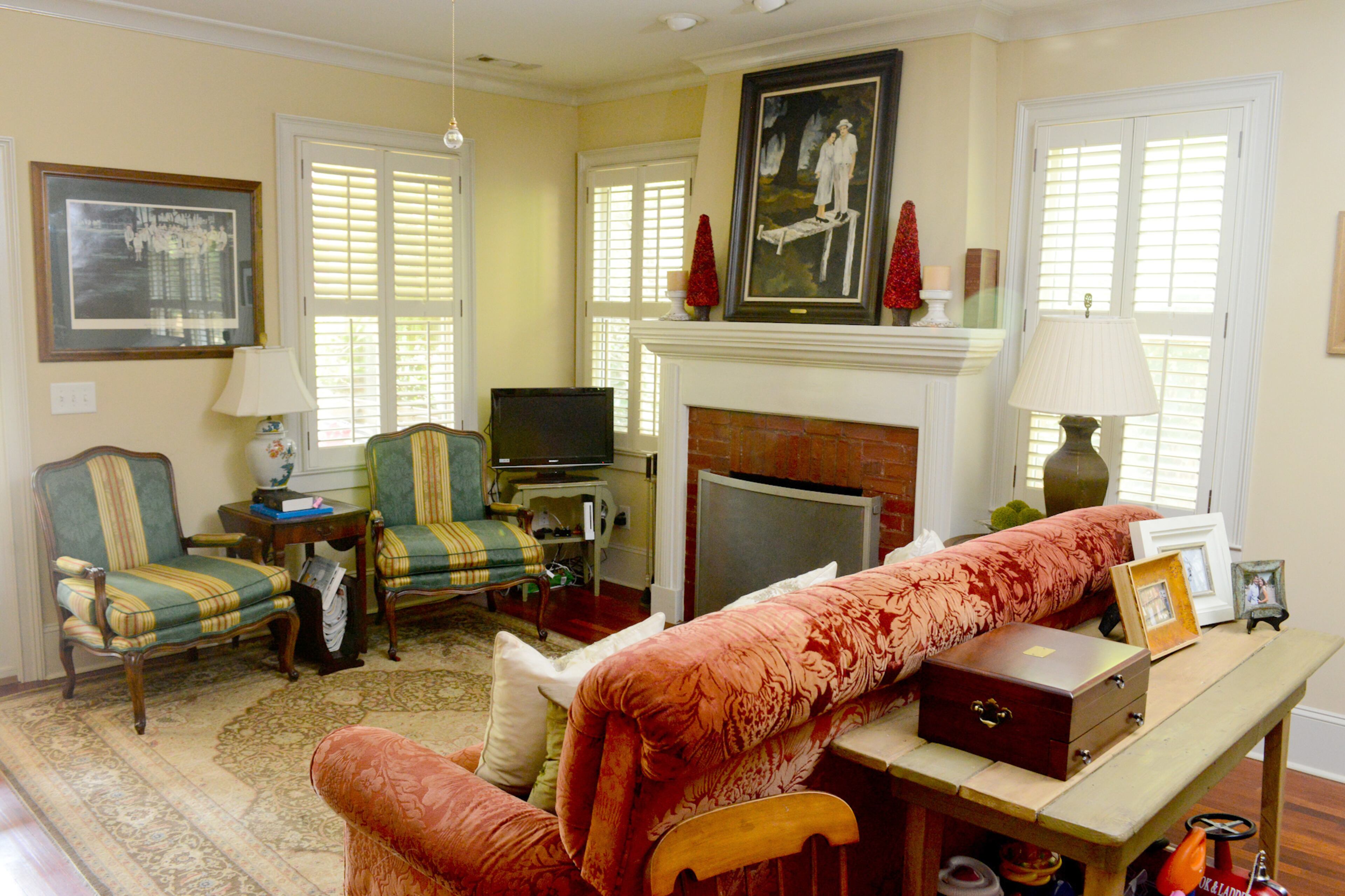 The shabby chic interiors include an overstuffed couch that was made in New Orleans, a pair of chairs they bought to reupholster and a vintage rug in the living room. “Mismatched works right now,” said homeowner Robert Phalen.