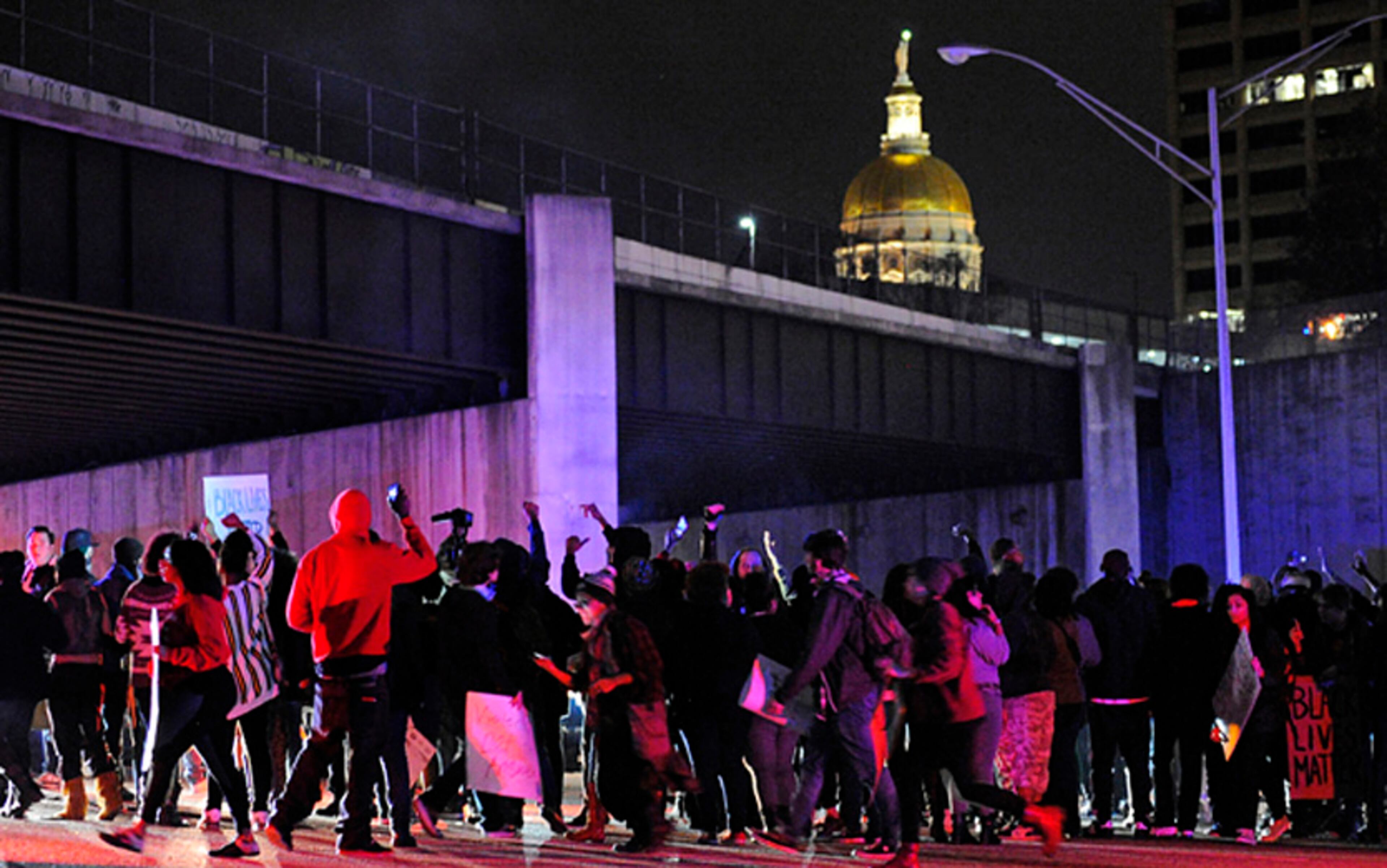 Protesters block all lanes of Interstate 75/85 northbound near the state capitol building one day after the Ferguson, Missouri, grand jury decision not to indict police officer Darren Wilson in the shooting of Mike Brown, on Tuesday, Nov. 25, 2014, in Atlanta. (AP Photo/David Tulis)