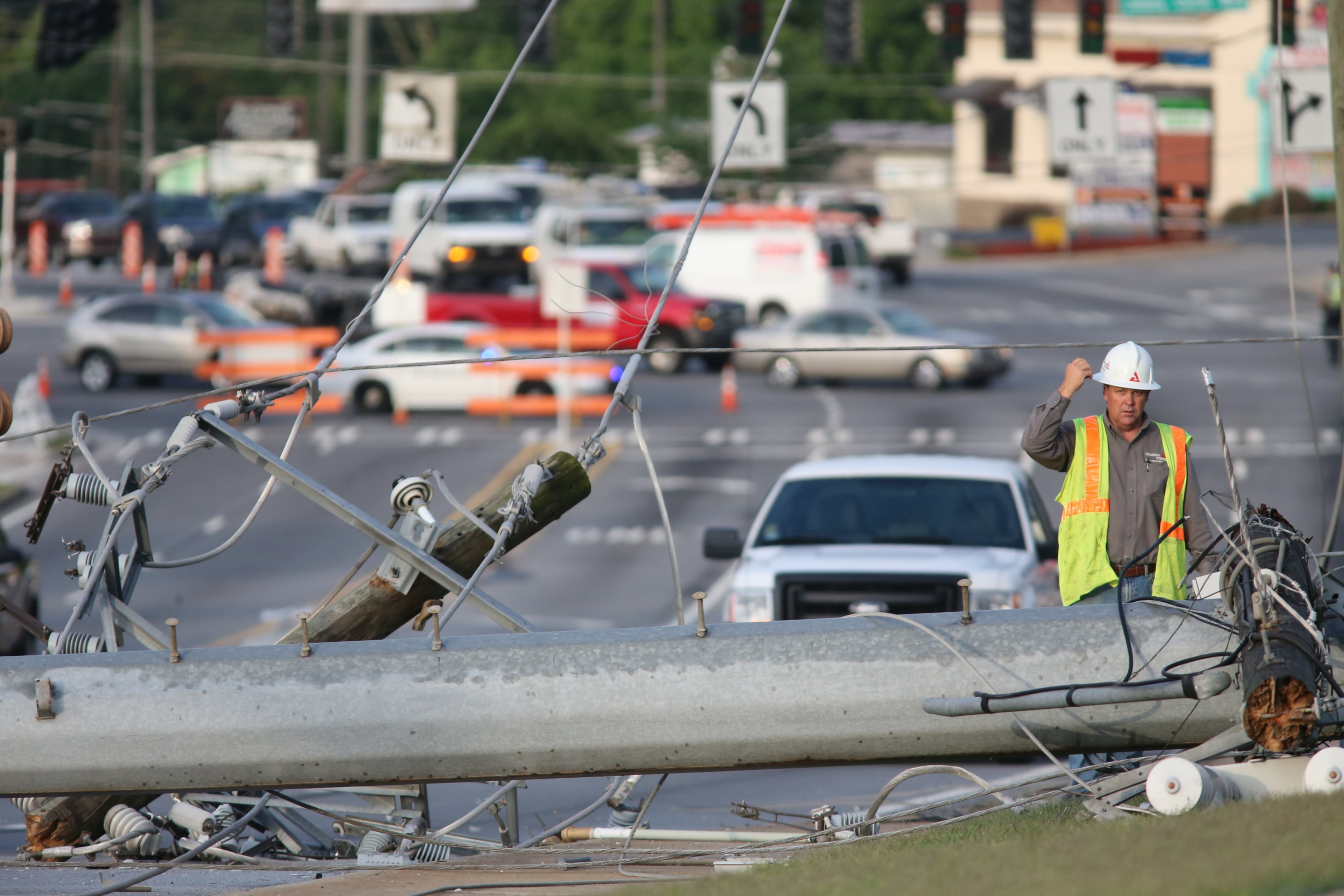 A second pole also fell onto a nearby grassy area. It was not immediately clear what caused the poles to topple. JOHN SPINK/JSPINK@AJC.COM