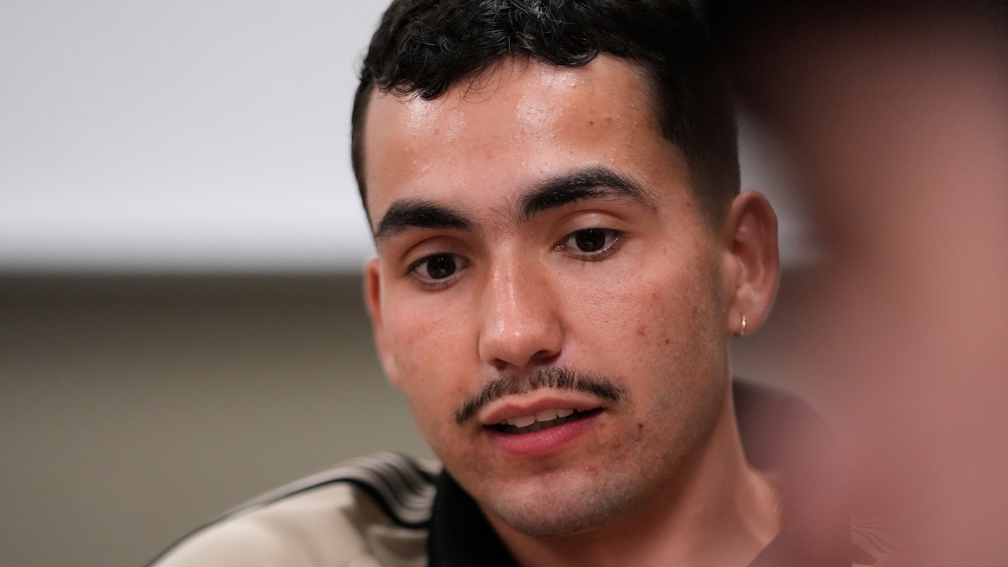 Michigan State University senior Frankie Llerandi listens to a discussion at a campaign event for William Lawrence, the Democratic candidate for U.S. House of Representatives in Michigan's 7th District, on Sept. 15, 2026, in East Lansing, Mich. (AP Photo/Paul Sancya)
