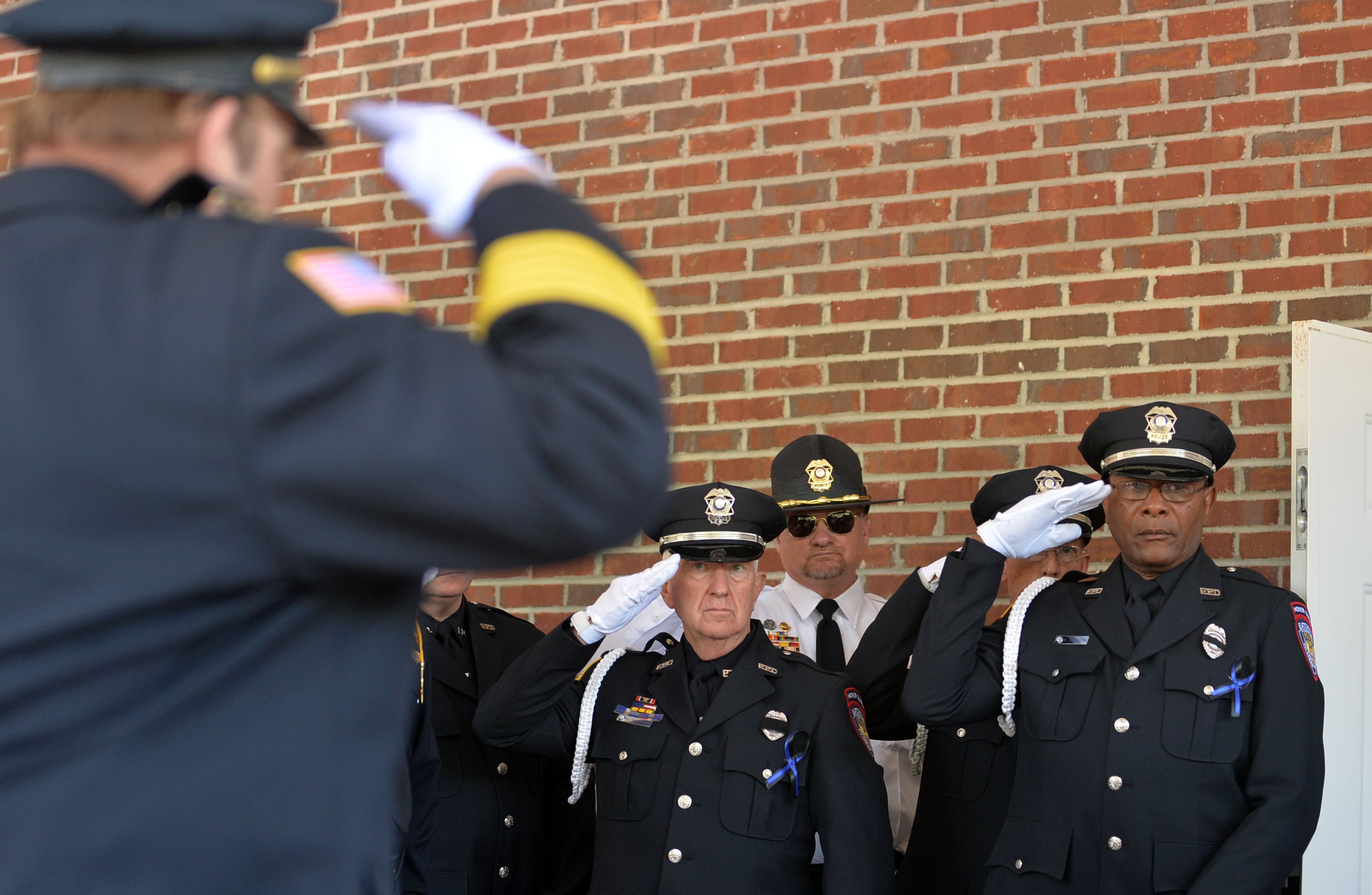 Fellow members of the Eatonton Police department salute in honor of their fallen officer at the A.E. Carter Funeral Home in Madison, Ga., where Officer Hawk was from. Officer Hawk served EPD for 12 years.